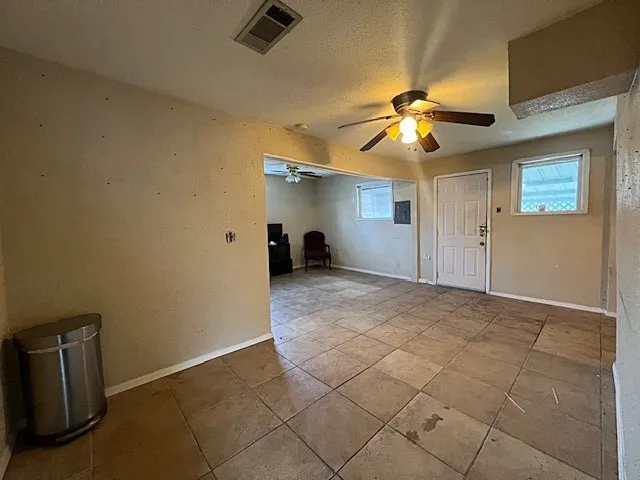 Back entryway featuring plenty of natural light, a textured ceiling, ceiling fan, and tile patterned floors