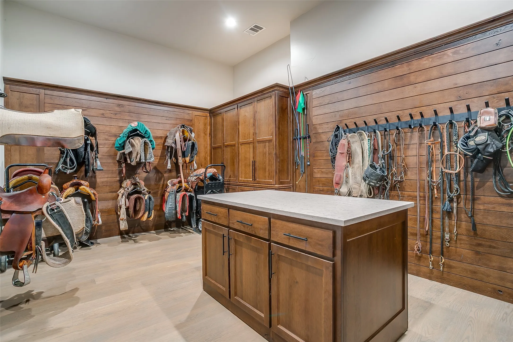 Custom barn interior showing climate-controlled tack room and equine medical suite.