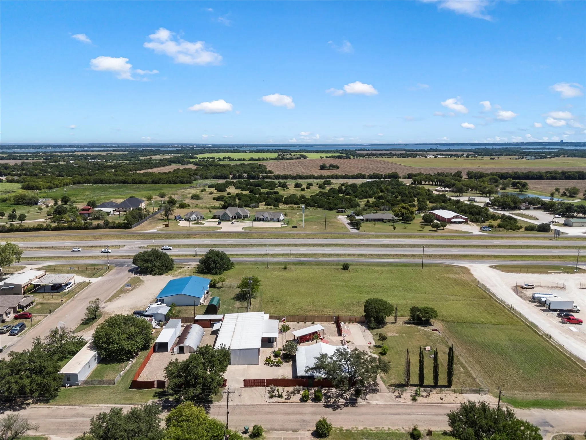 Aerial view of sparsely populated area with rows of crops