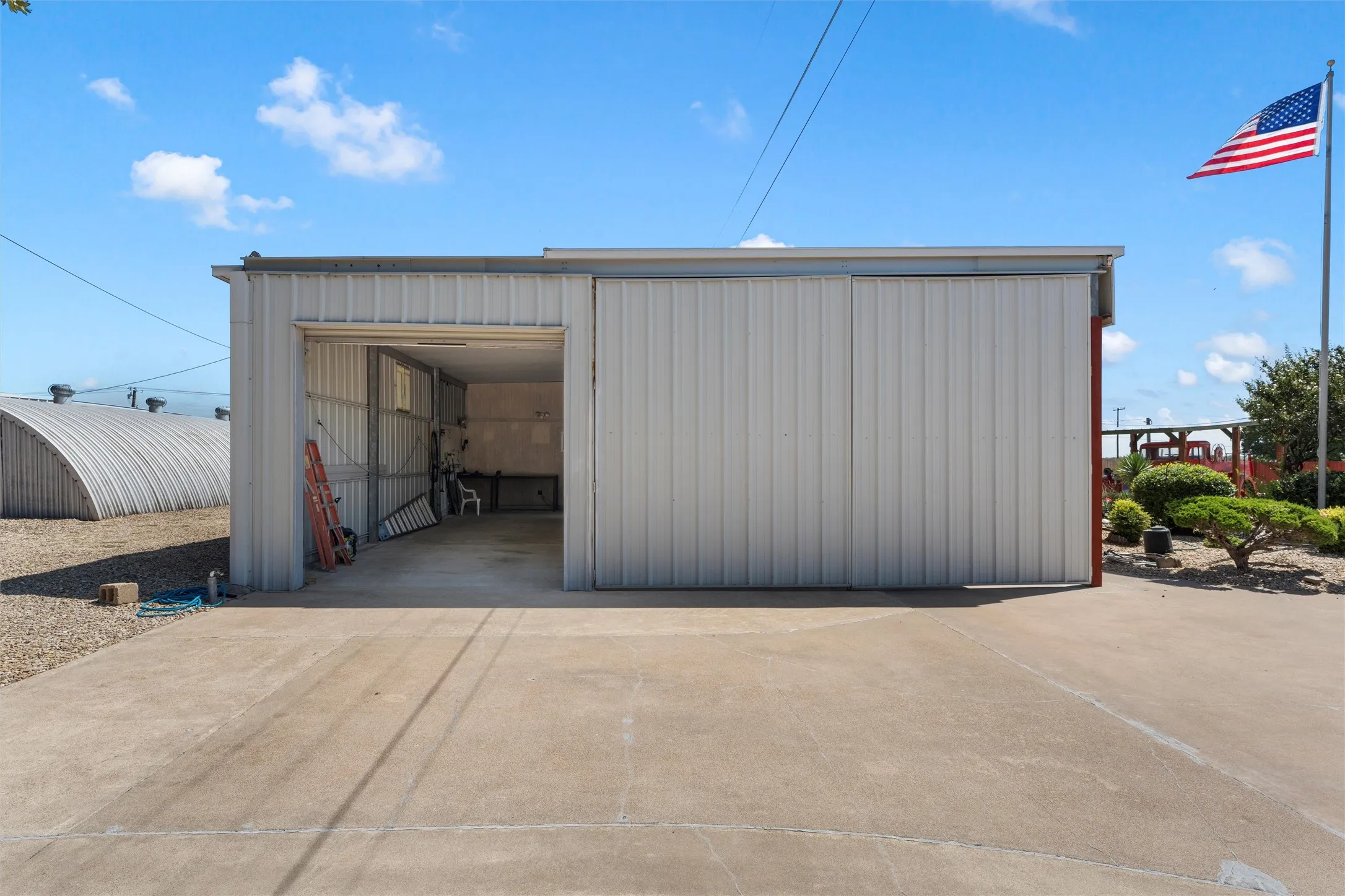 View of pole building with concrete driveway