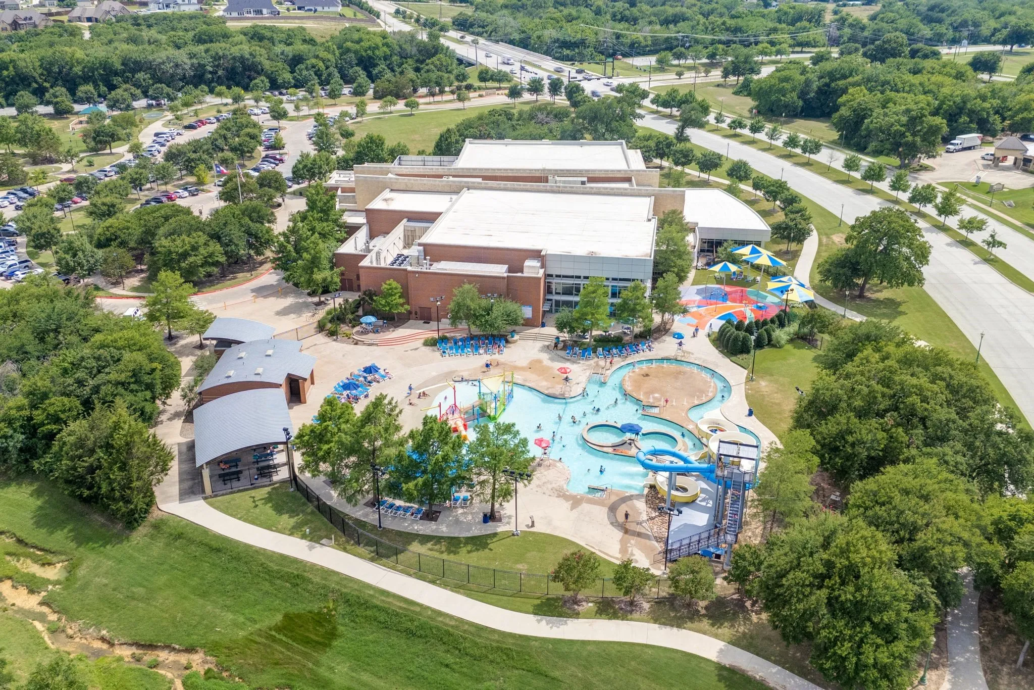 Aerial view of a pool area and a tree filled landscape