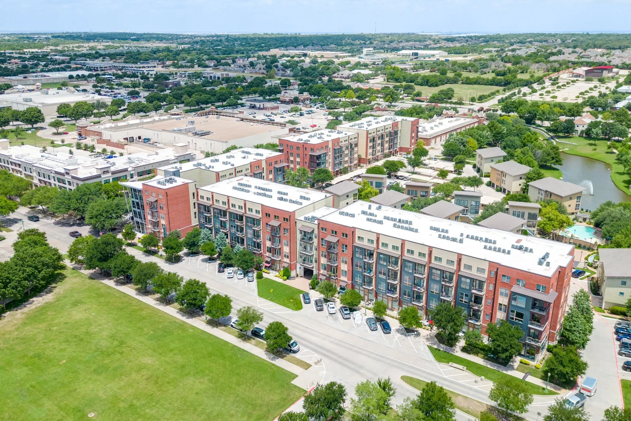 Drone / aerial view of apartment complex and a nearby body of water