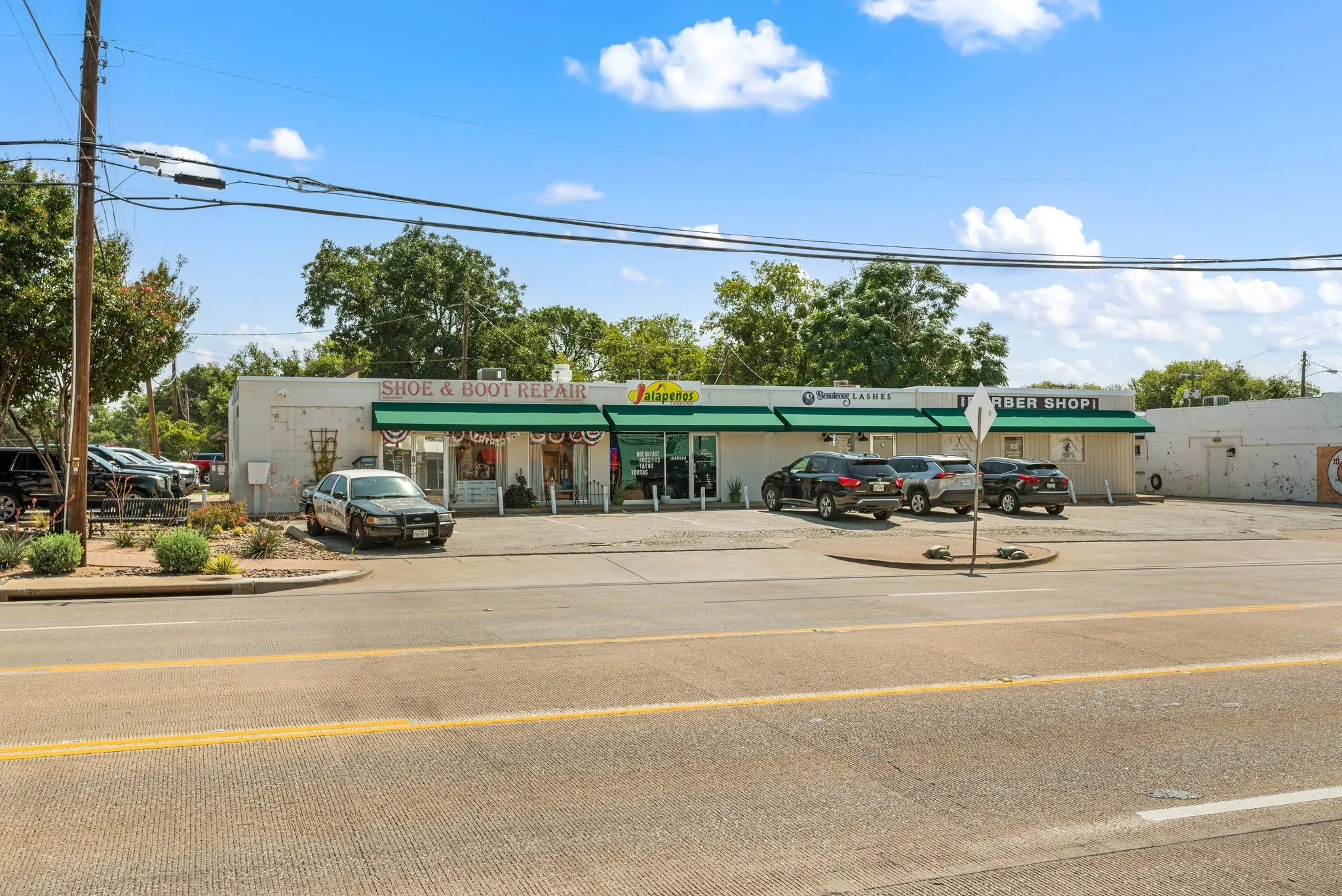 View of commercial property with uncovered parking