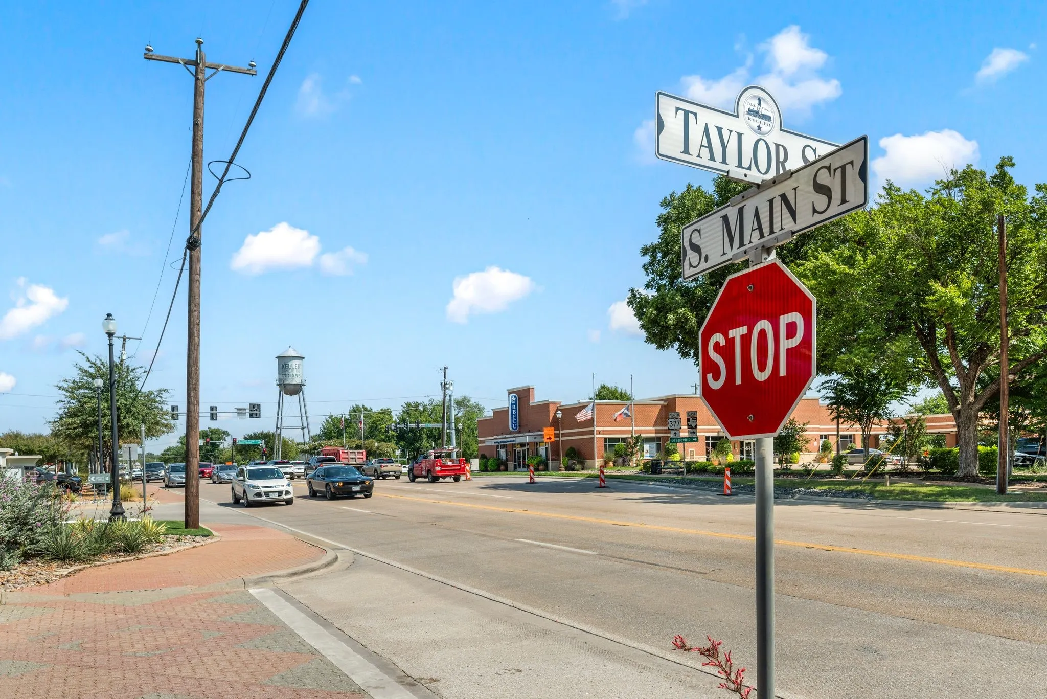 View of concrete road featuring curbs, sidewalks, and traffic signs