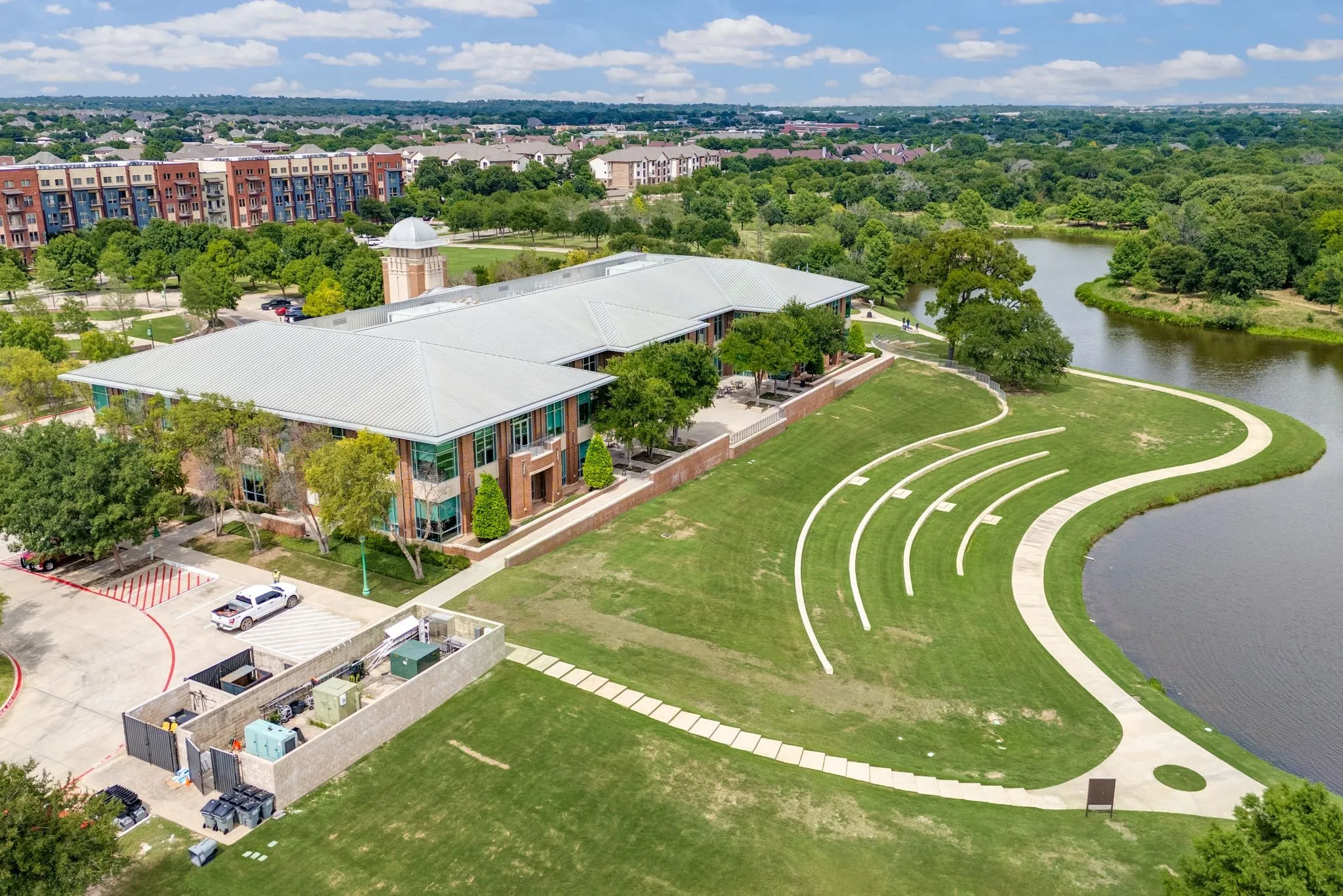 Drone / aerial view of a nearby body of water and a tree filled landscape