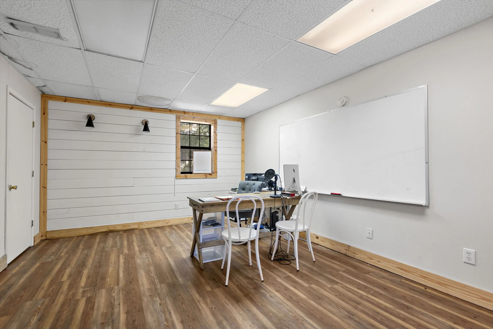 Dining space featuring wood finished floors, wood walls, a drop ceiling, and an office area