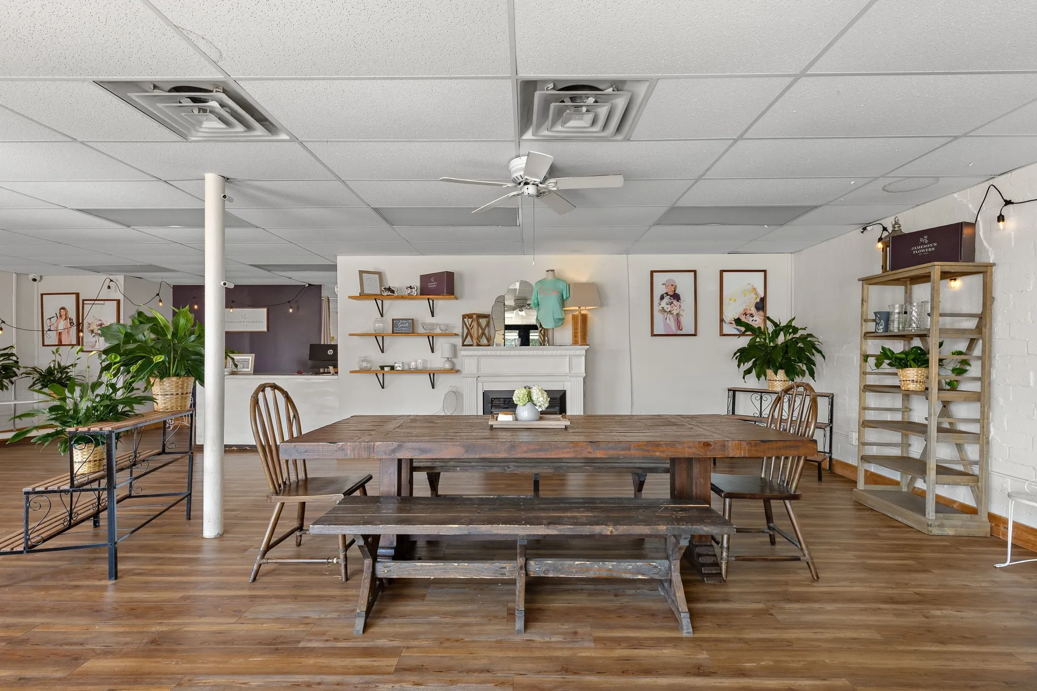 Dining space featuring ceiling fan, a fireplace, a paneled ceiling, and wood finished floors