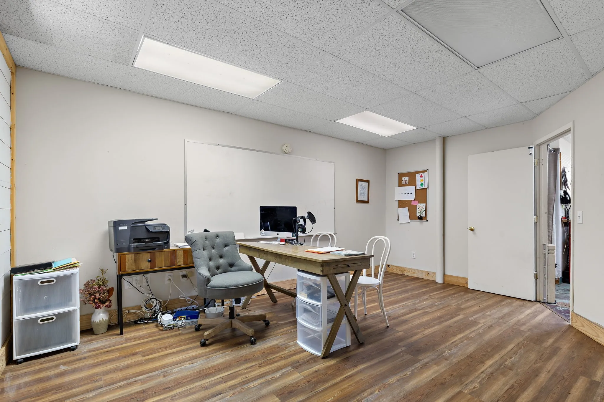 Office with wood finished floors and a drop ceiling