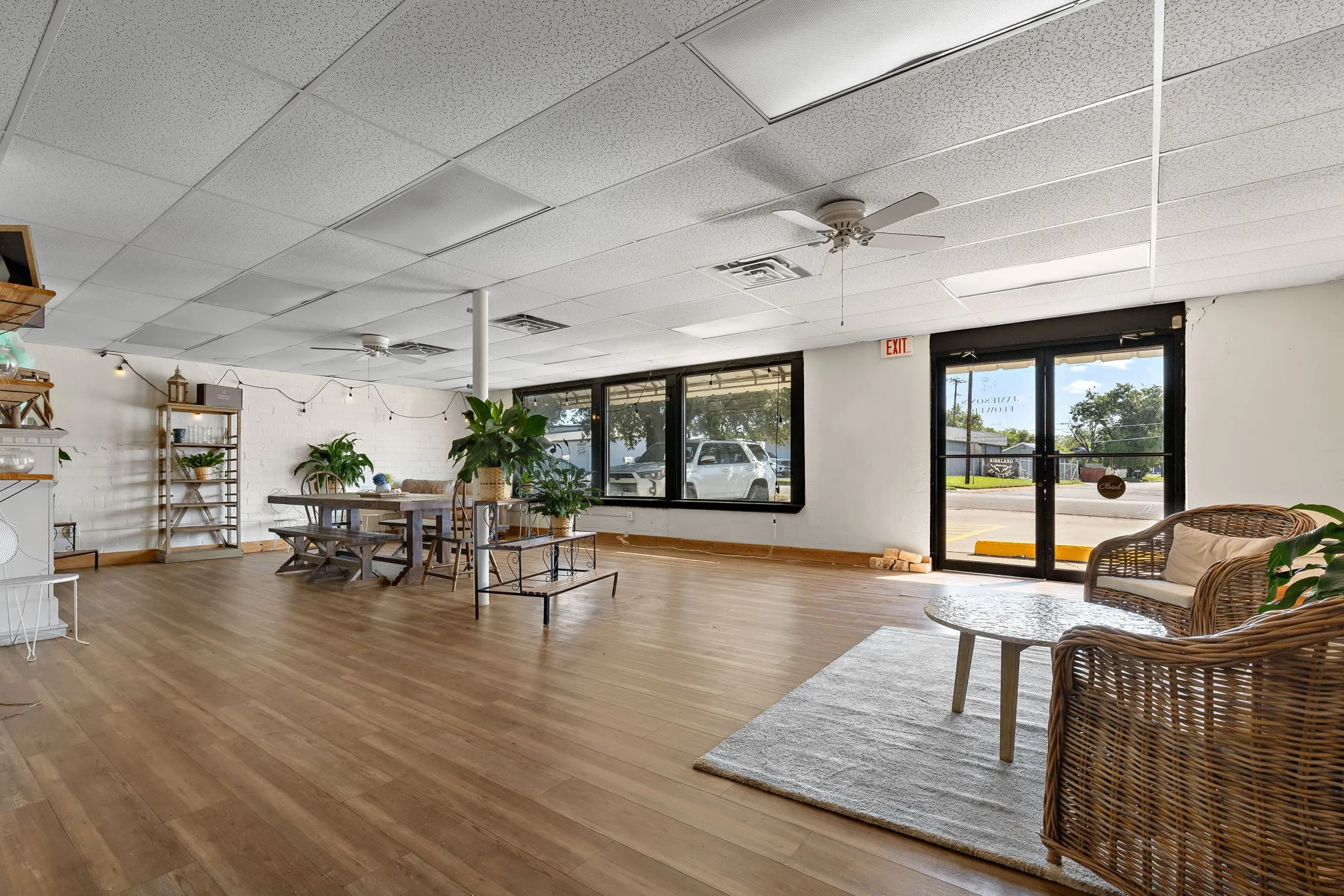 Living room with ceiling fan, a drop ceiling, and light wood finished floors