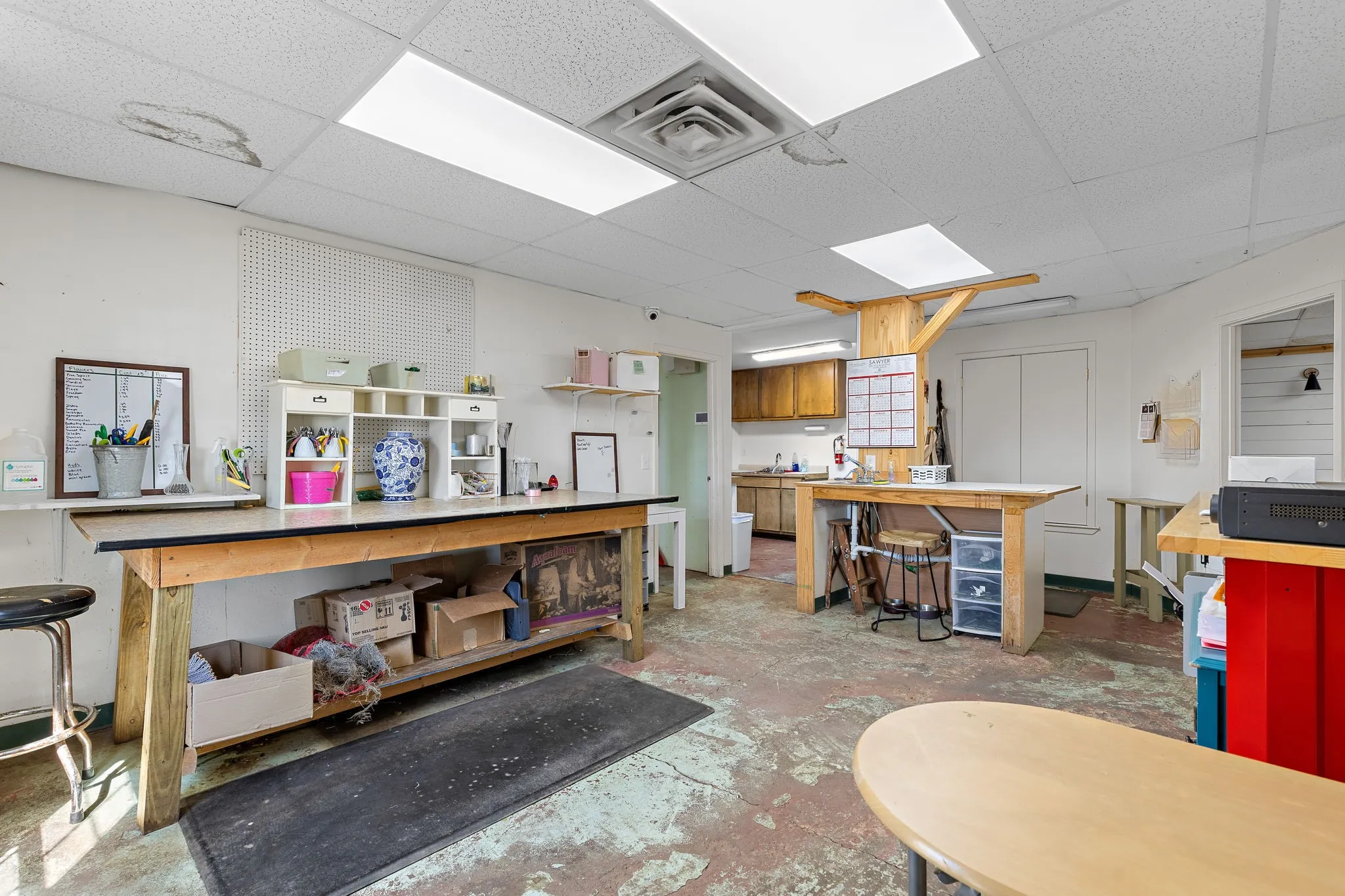 Misc room featuring concrete flooring and a paneled ceiling