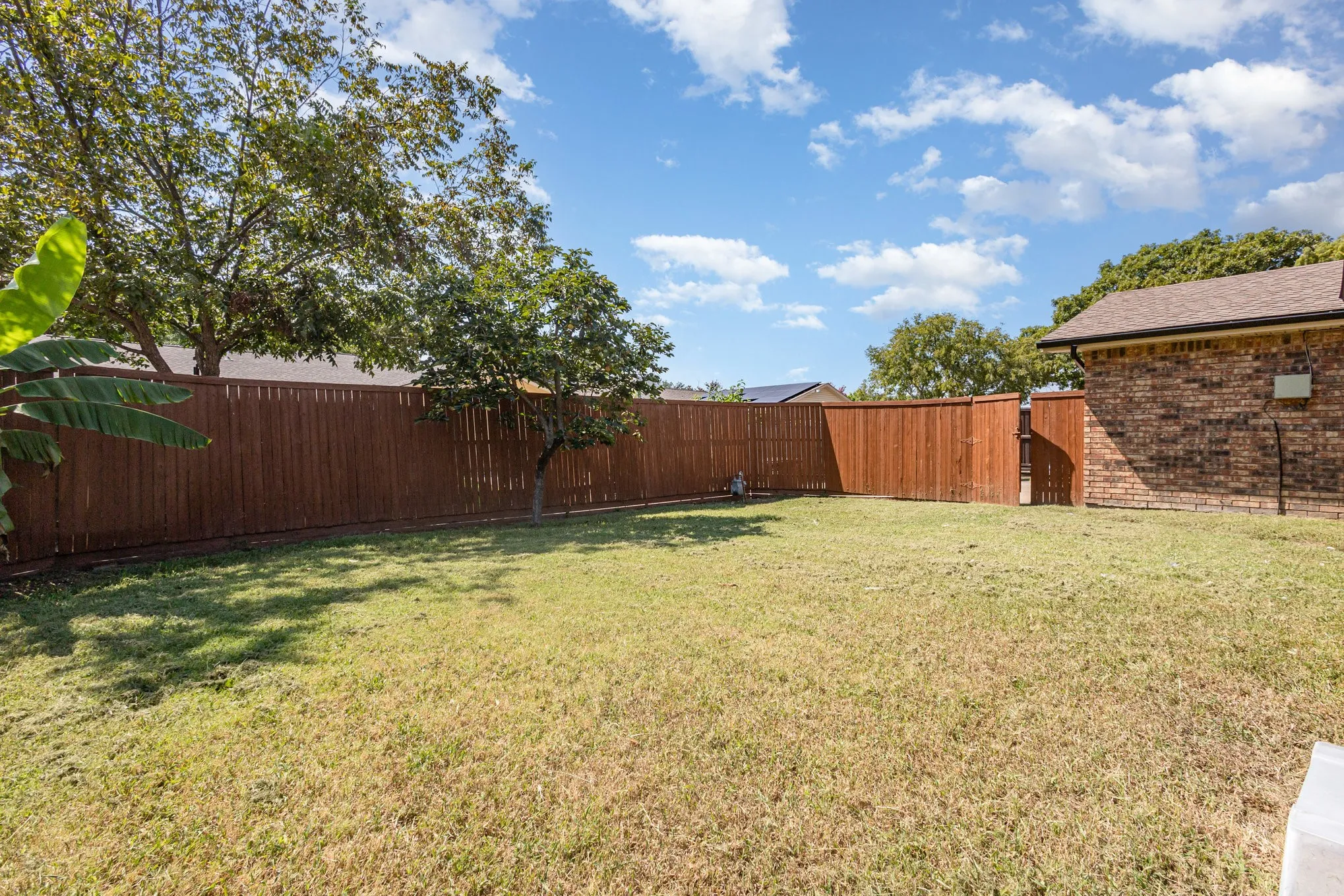 Fenced backyard featuring a gate