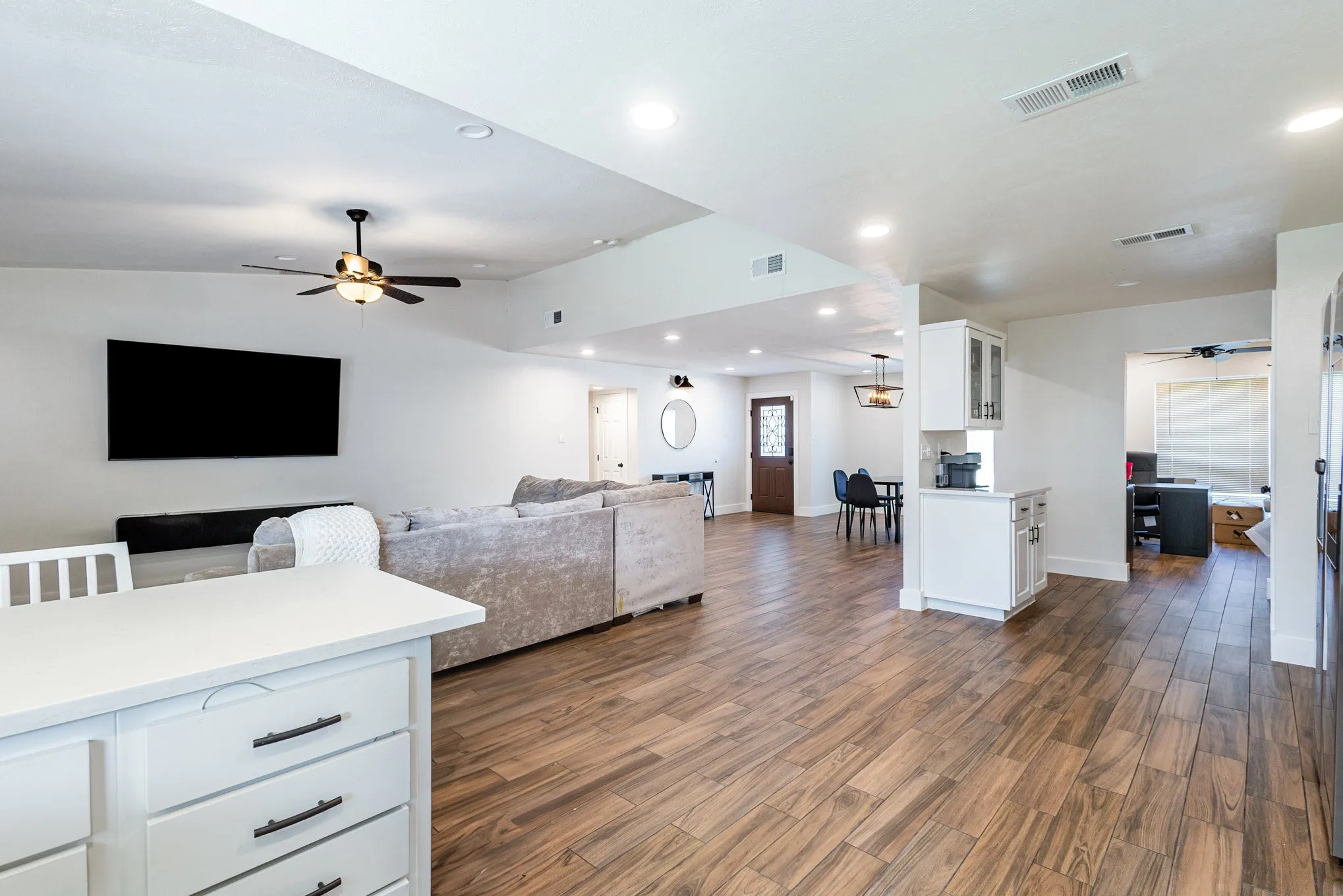 Living room featuring ceiling fan, dark wood-style floors, and recessed lighting