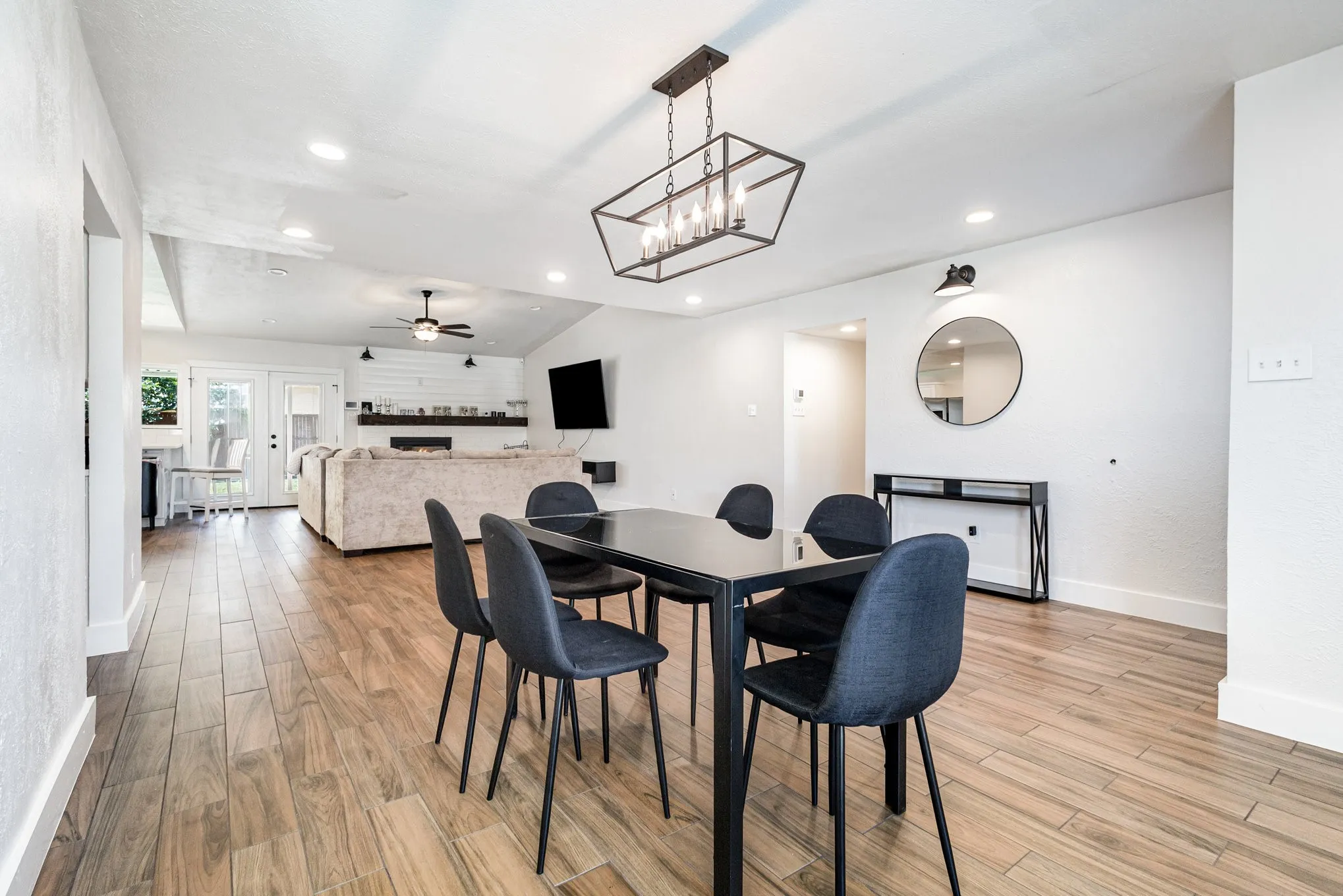 Dining area with a fireplace, a chandelier, light wood-style flooring, recessed lighting, and a ceiling fan