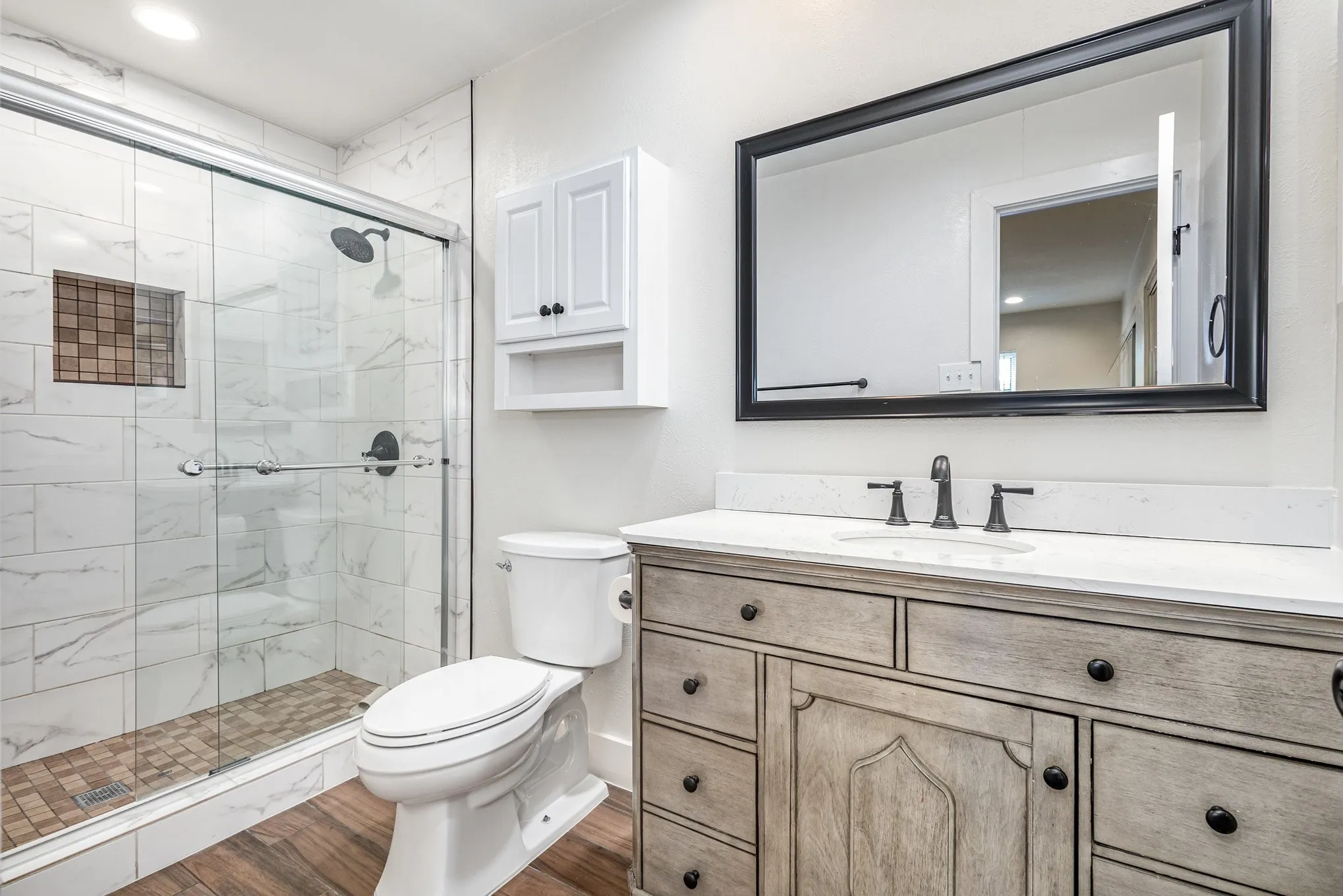 Full bathroom featuring vanity, a shower stall, and wood finished floors