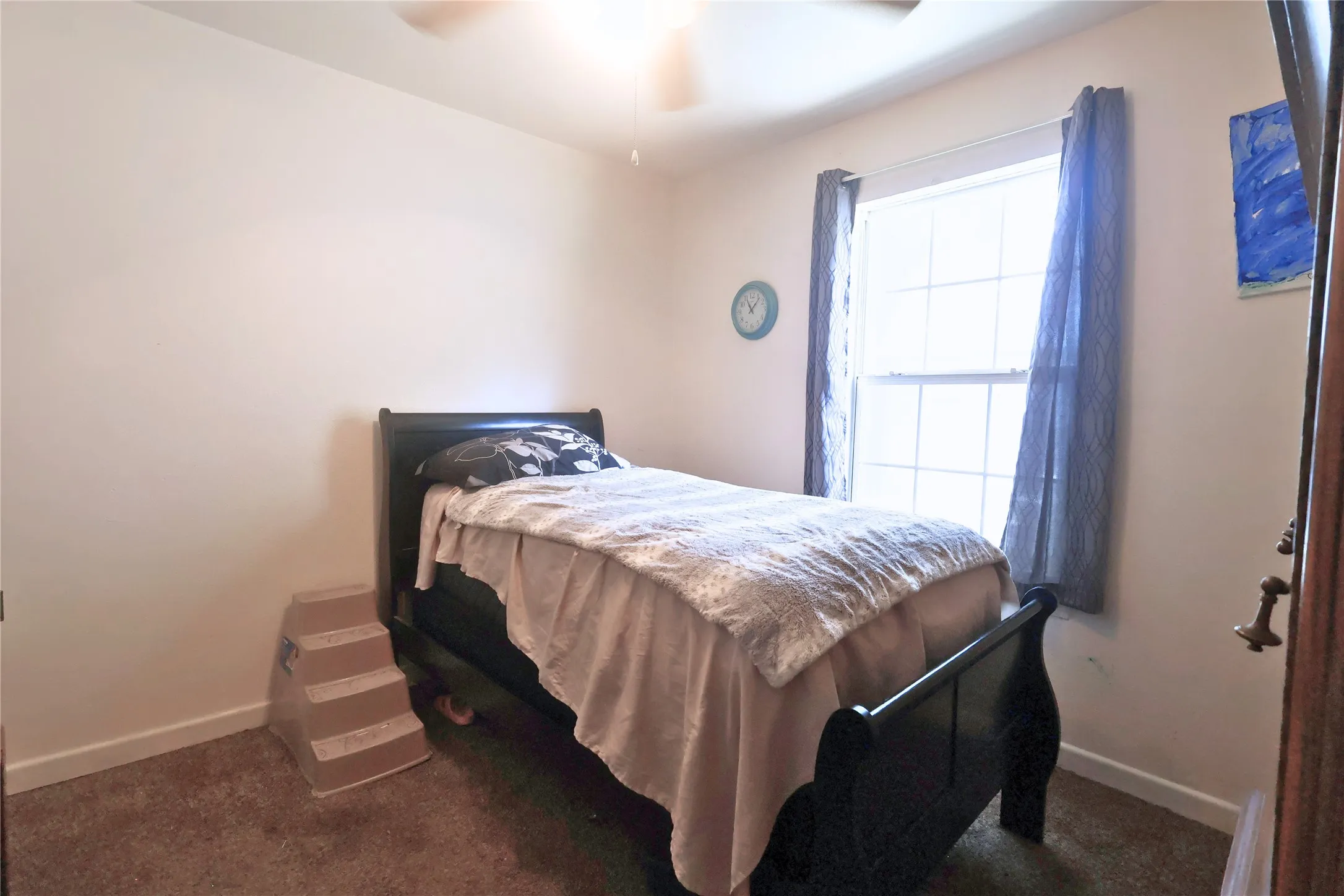 Bedroom with ceiling fan and dark carpet