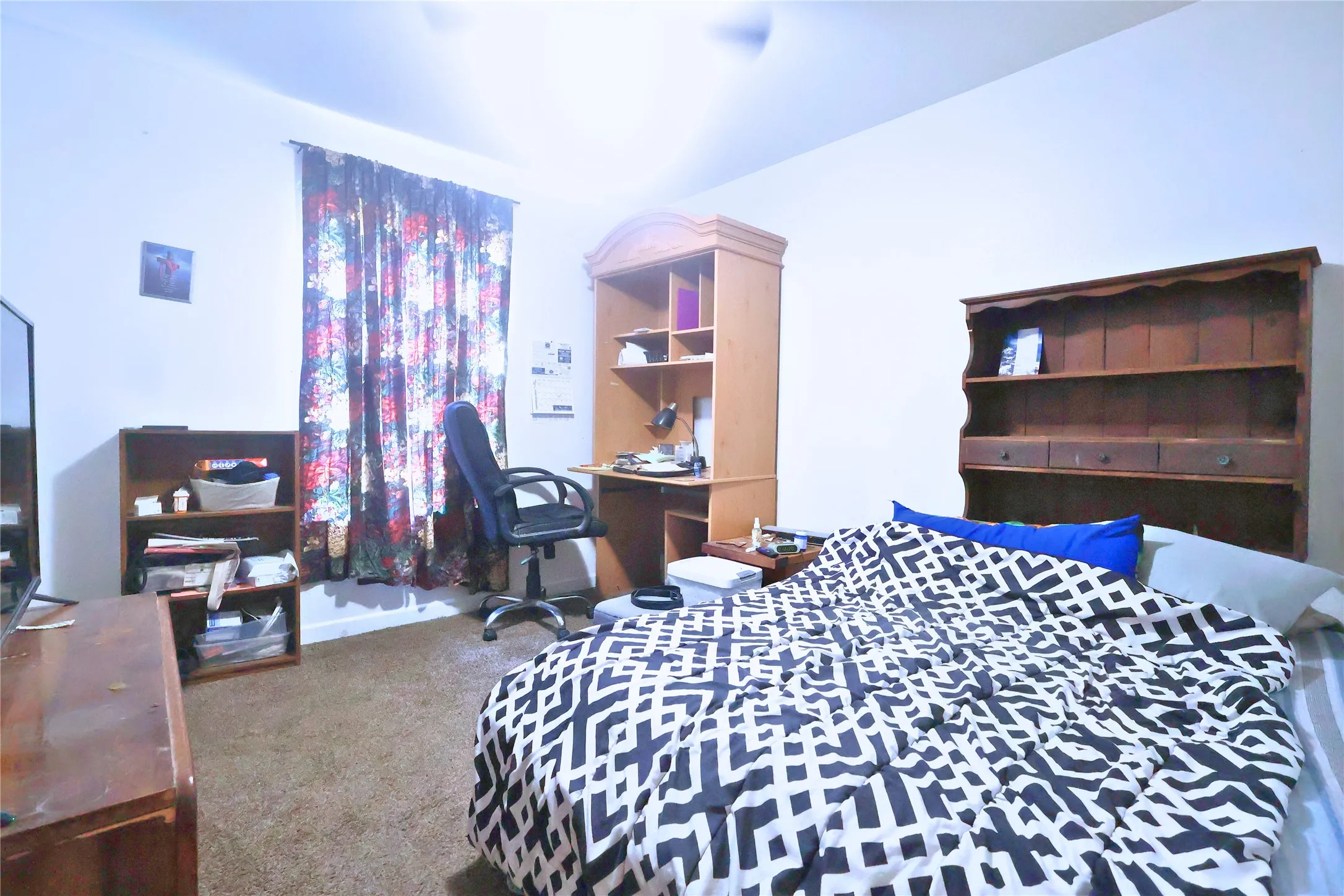 Bedroom featuring light colored carpet, a desk, and a ceiling fan