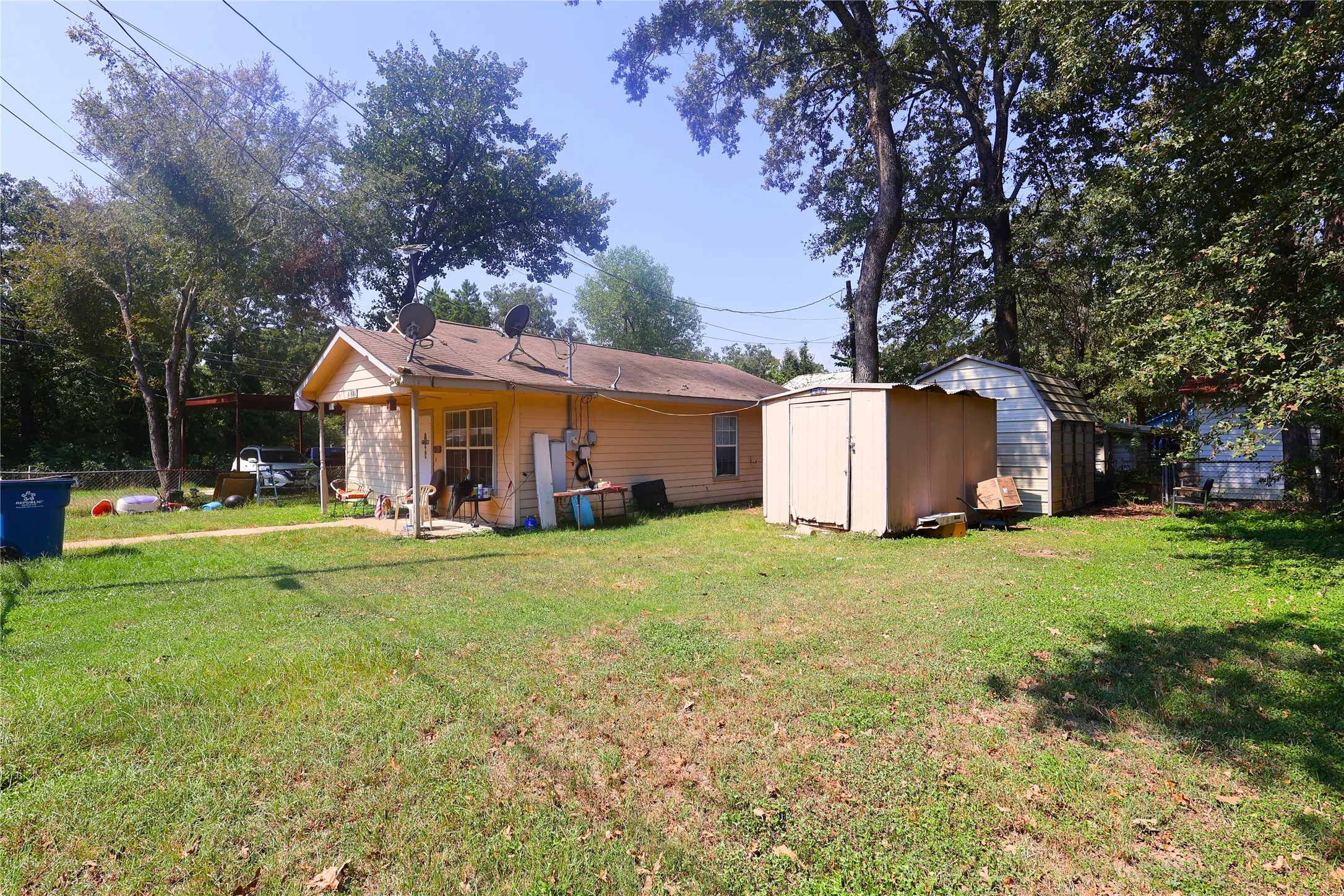 Back of property with a shed and a patio