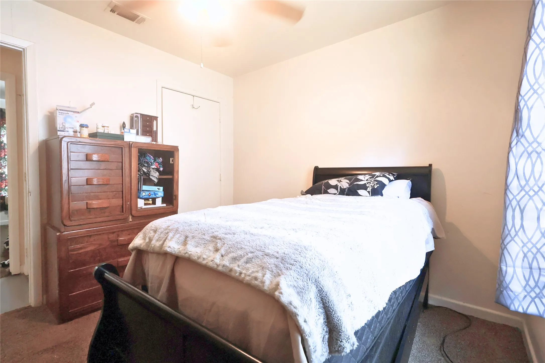Bedroom with a closet, carpet floors, and a ceiling fan