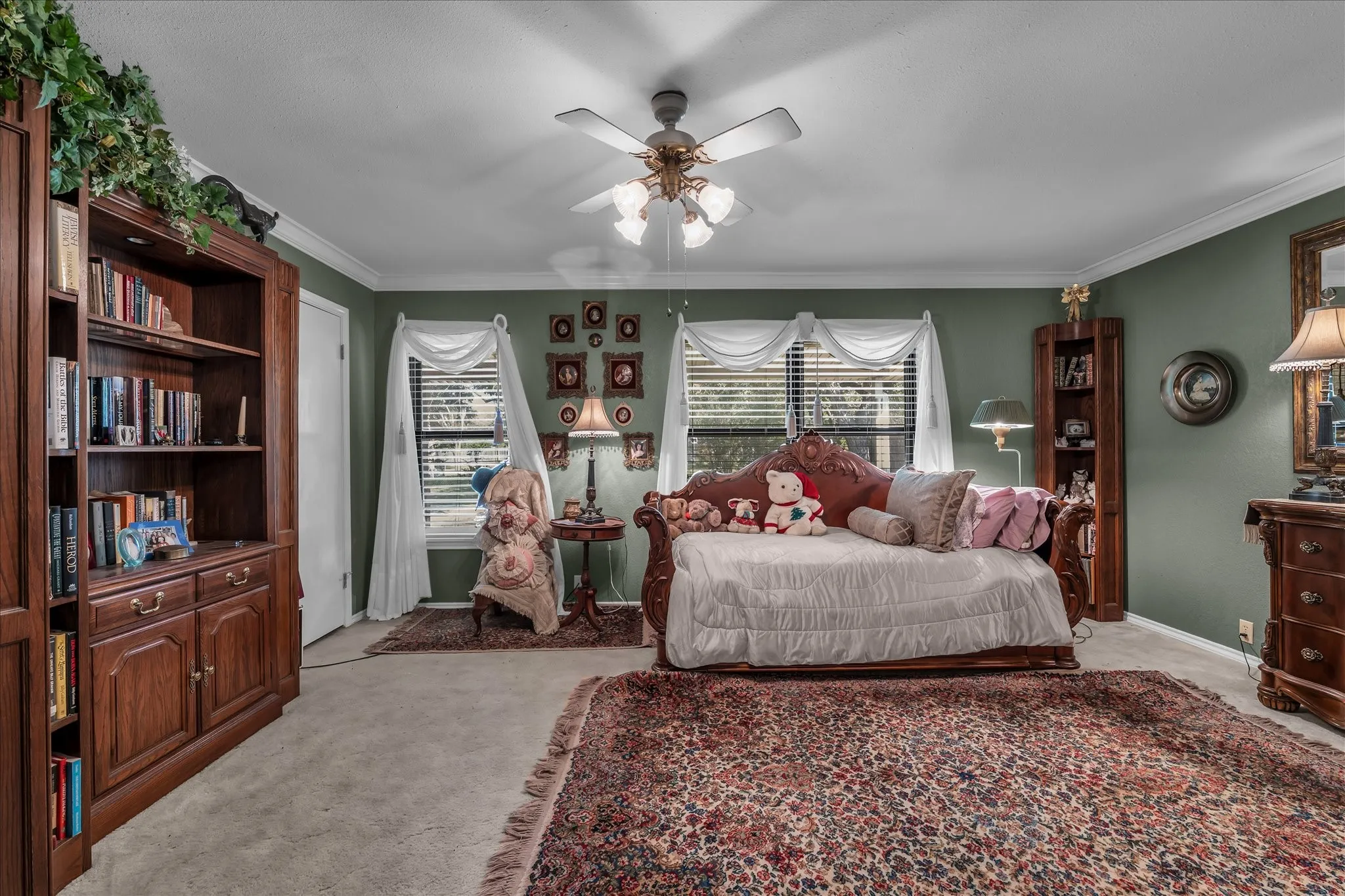 Bedroom with multiple windows, light carpet, ornamental molding, and a ceiling fan