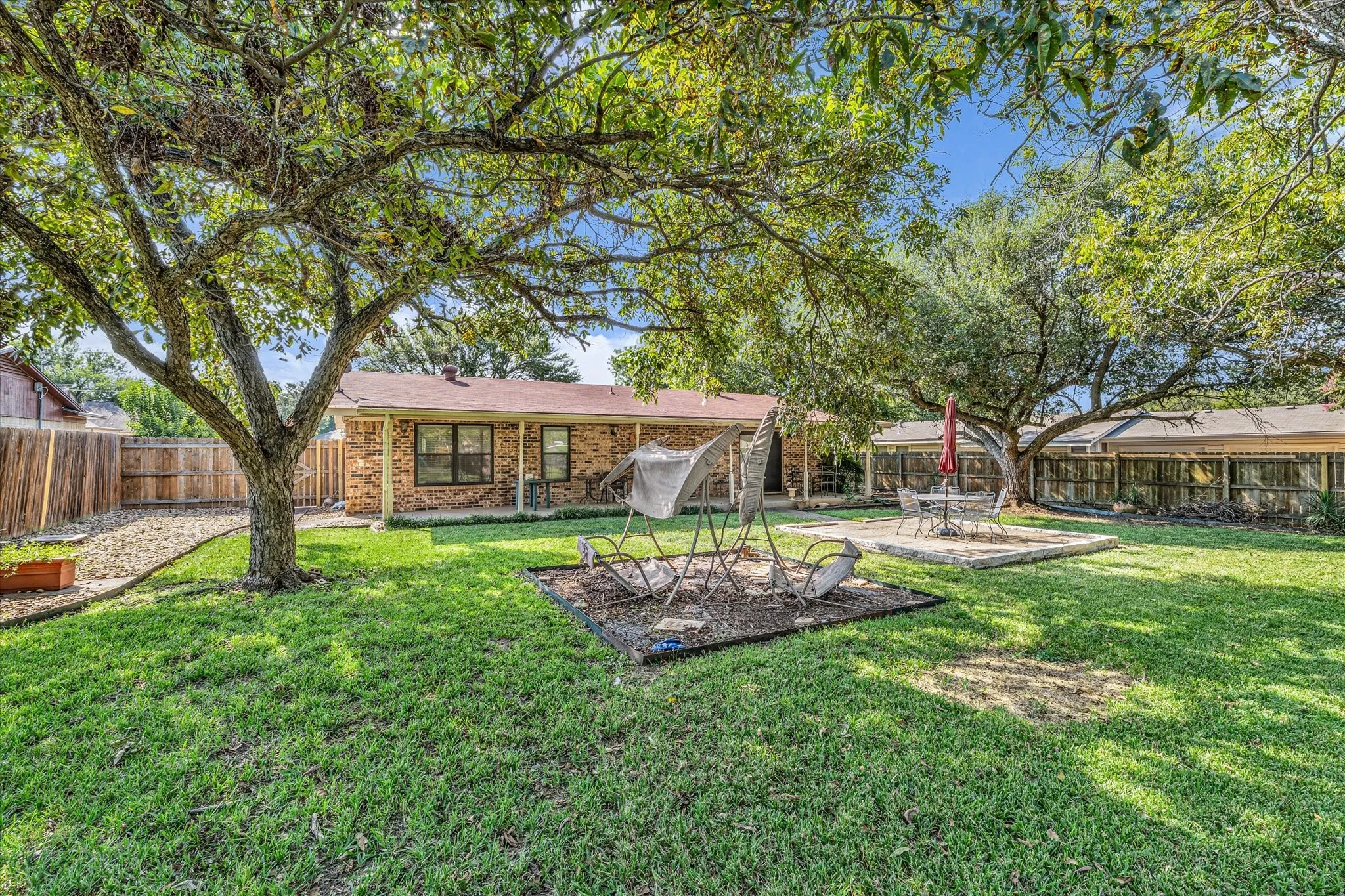 Back of house with a fenced backyard and brick siding