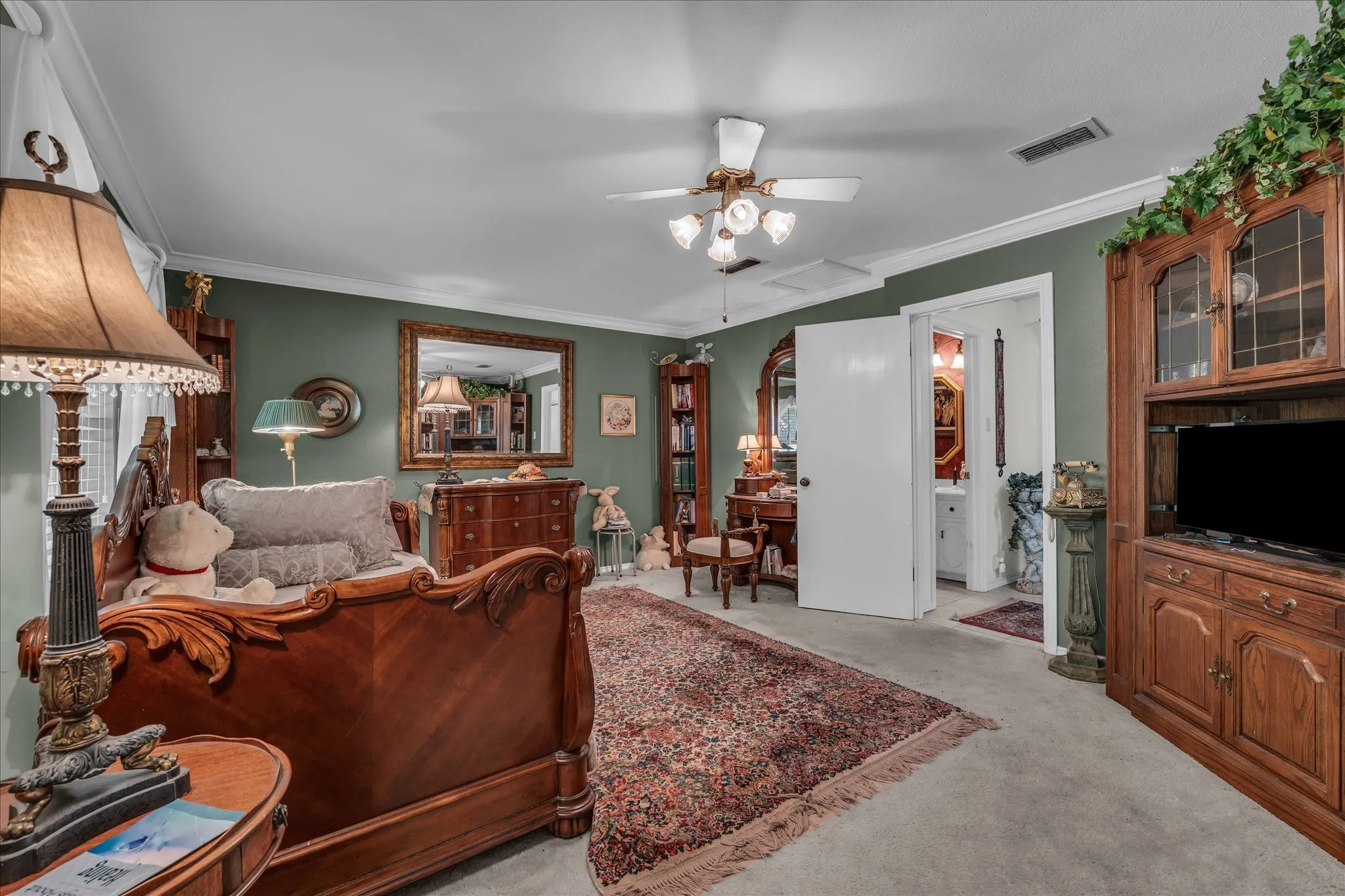 Living area with crown molding, light colored carpet, and a ceiling fan