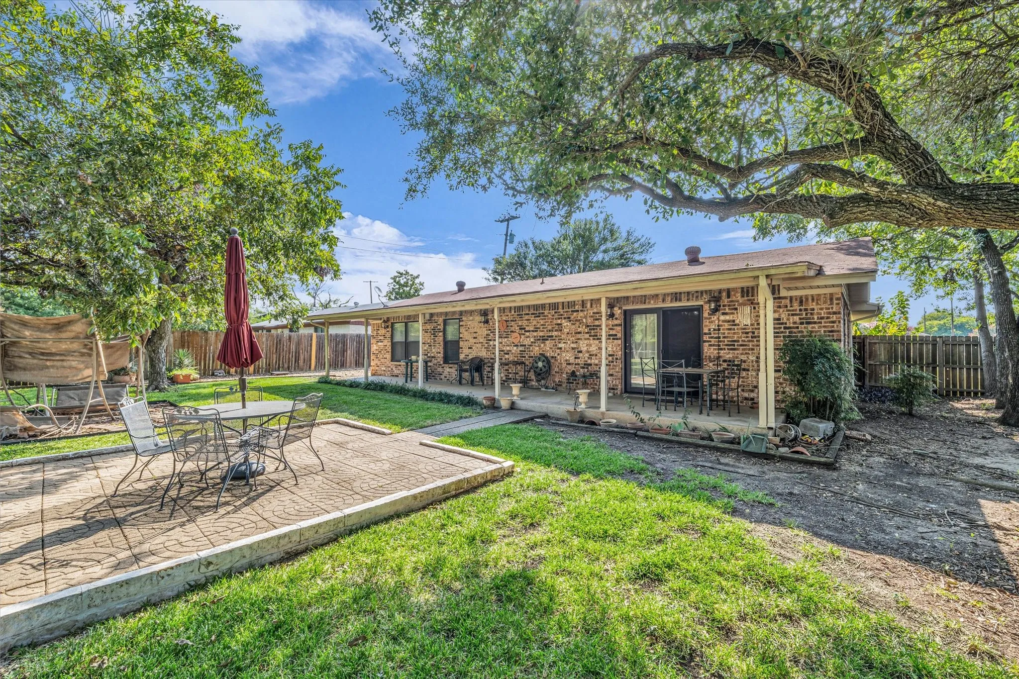 Back of house featuring a patio area, a fenced backyard, and brick siding