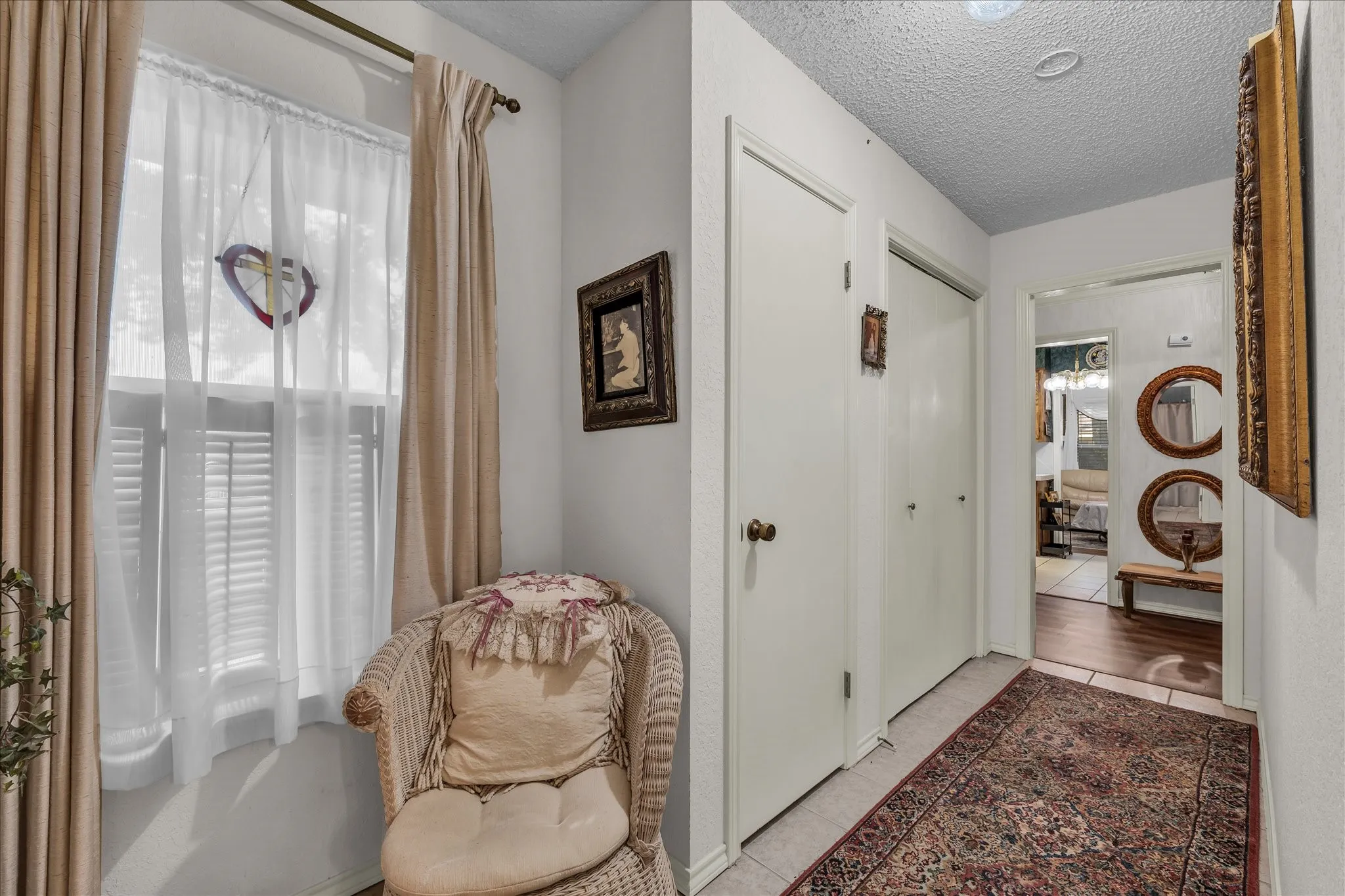 Hallway featuring a textured ceiling and tile patterned floors