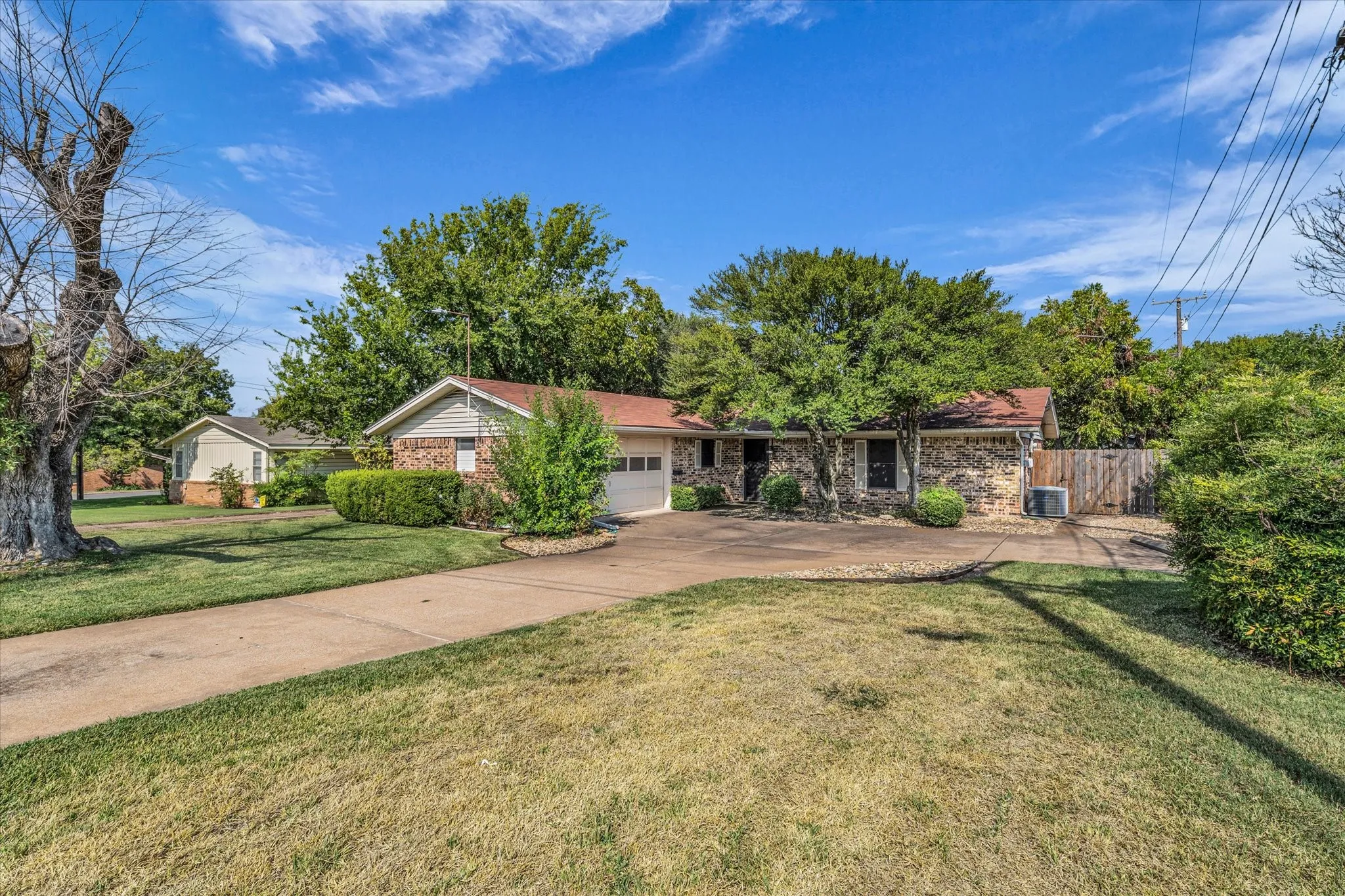 Ranch-style house with brick siding, concrete driveway, and an attached garage