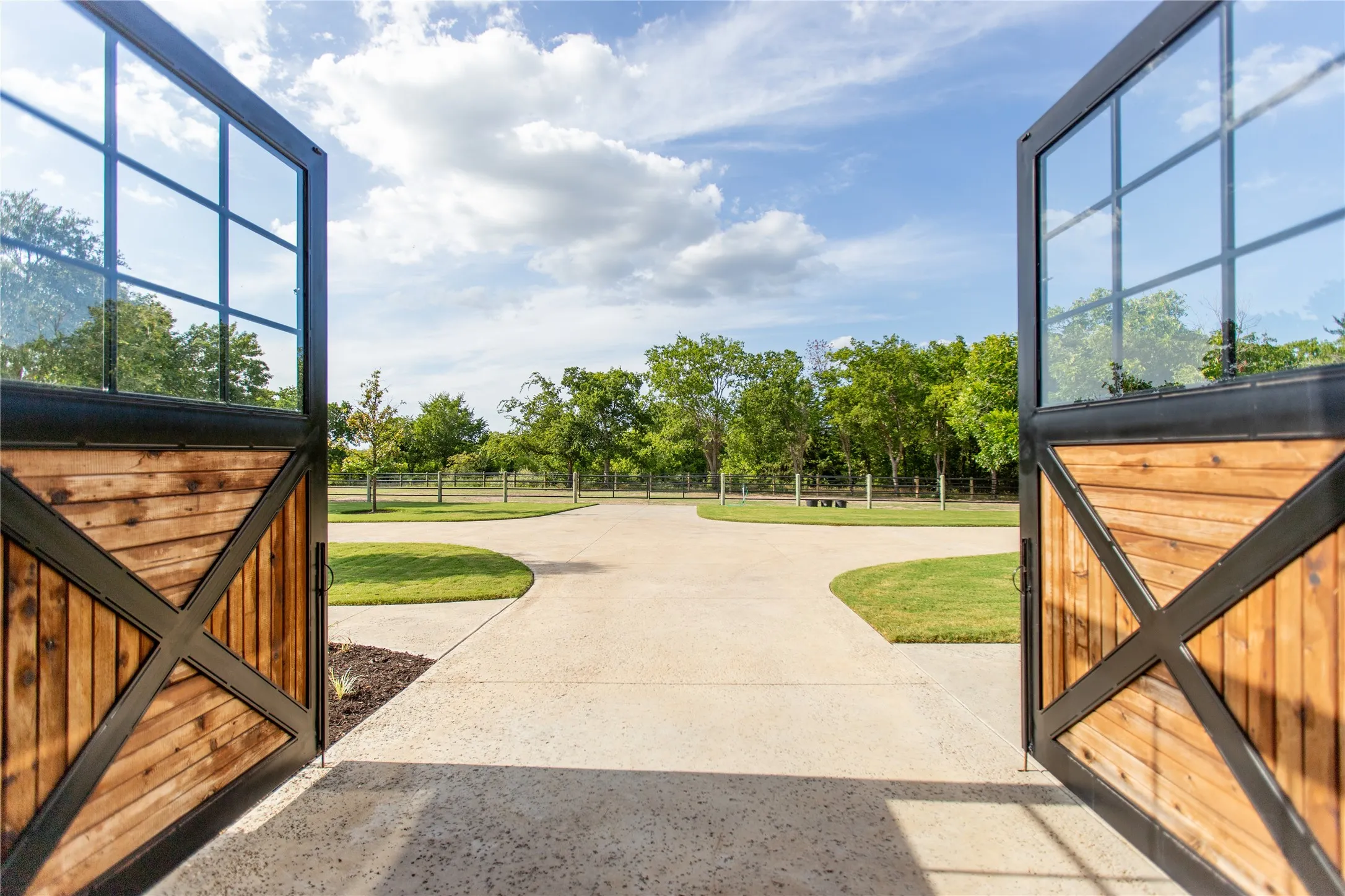 Oversized custom barn doors open directly from the alleyway towards the pastures creating seamless access and natural flow.