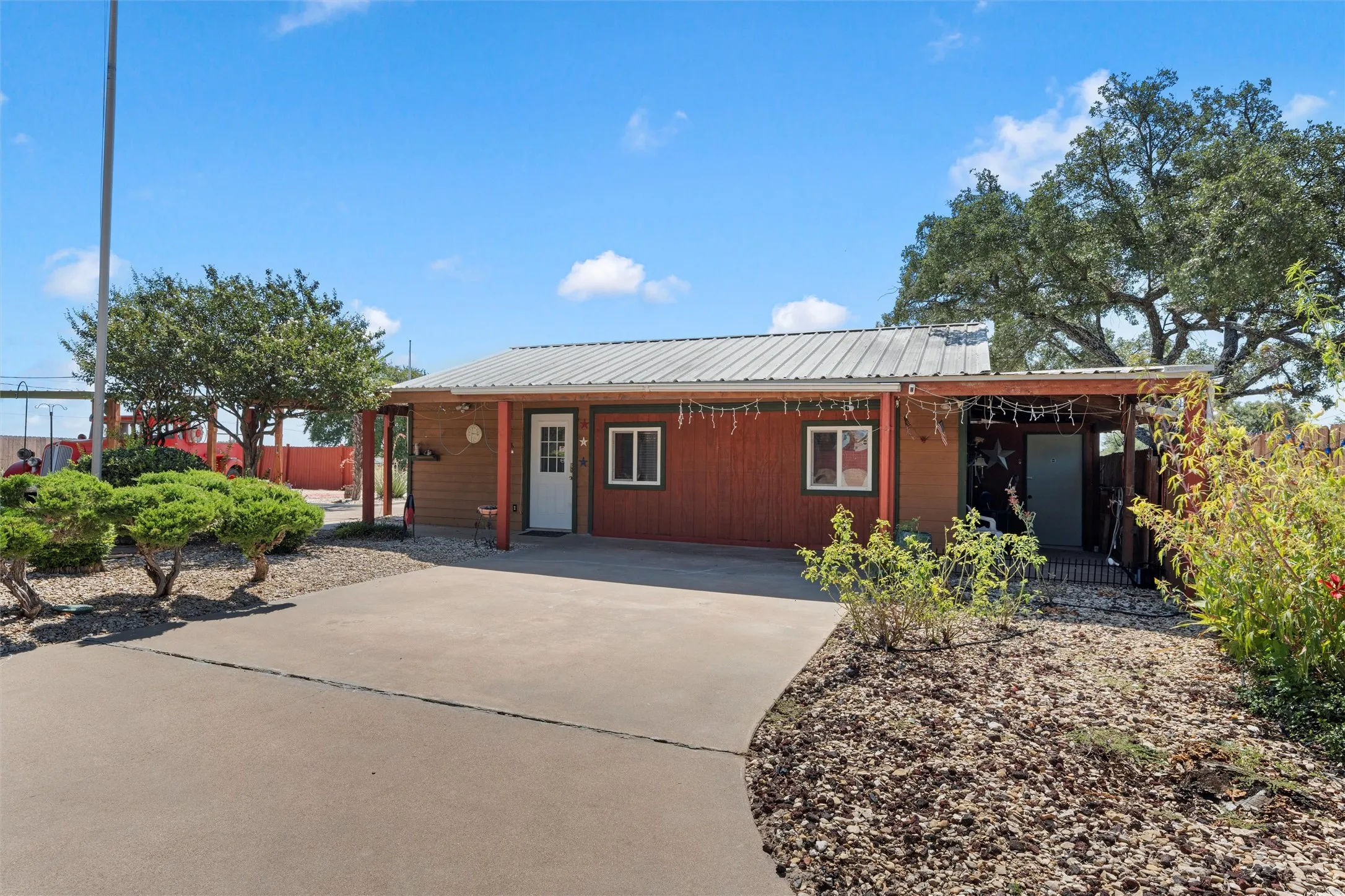 View of front of house featuring a metal roof and concrete driveway