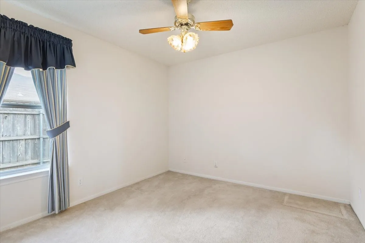 Unfurnished room featuring light carpet and ceiling fan