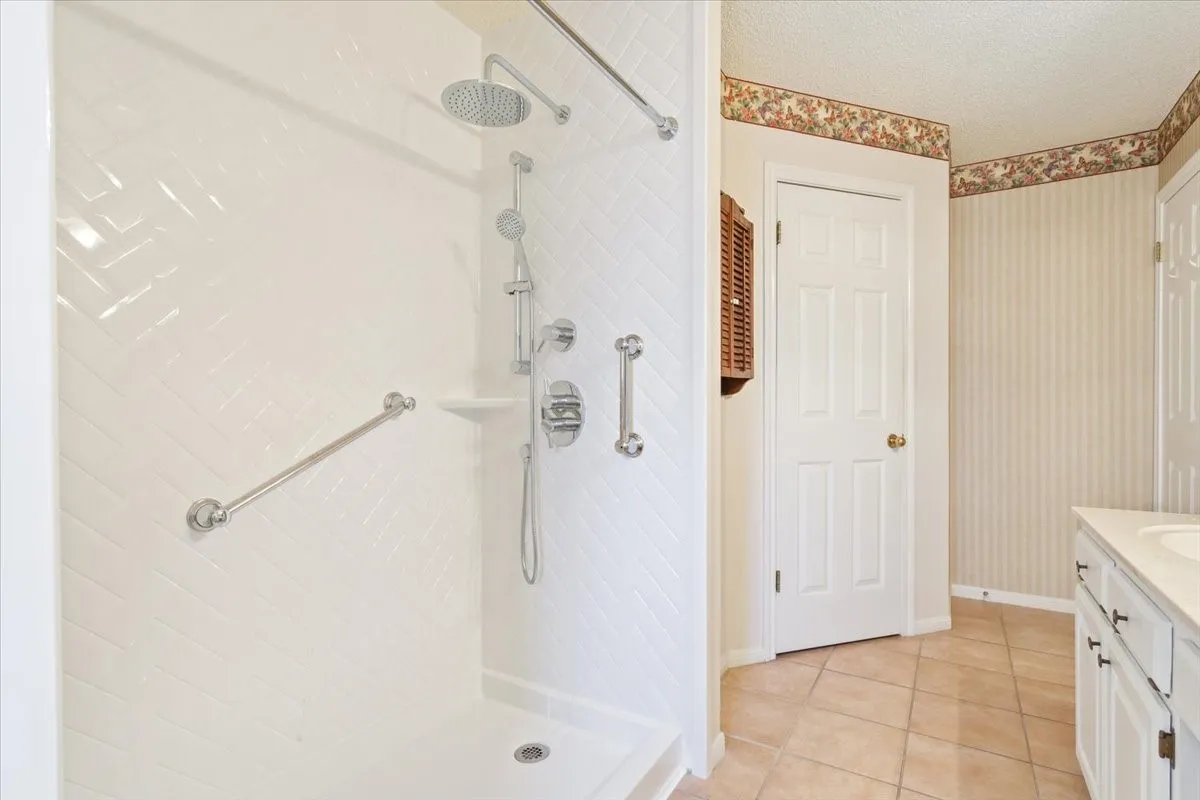 Bathroom with vanity, a stall shower, light tile patterned floors, and a textured ceiling
