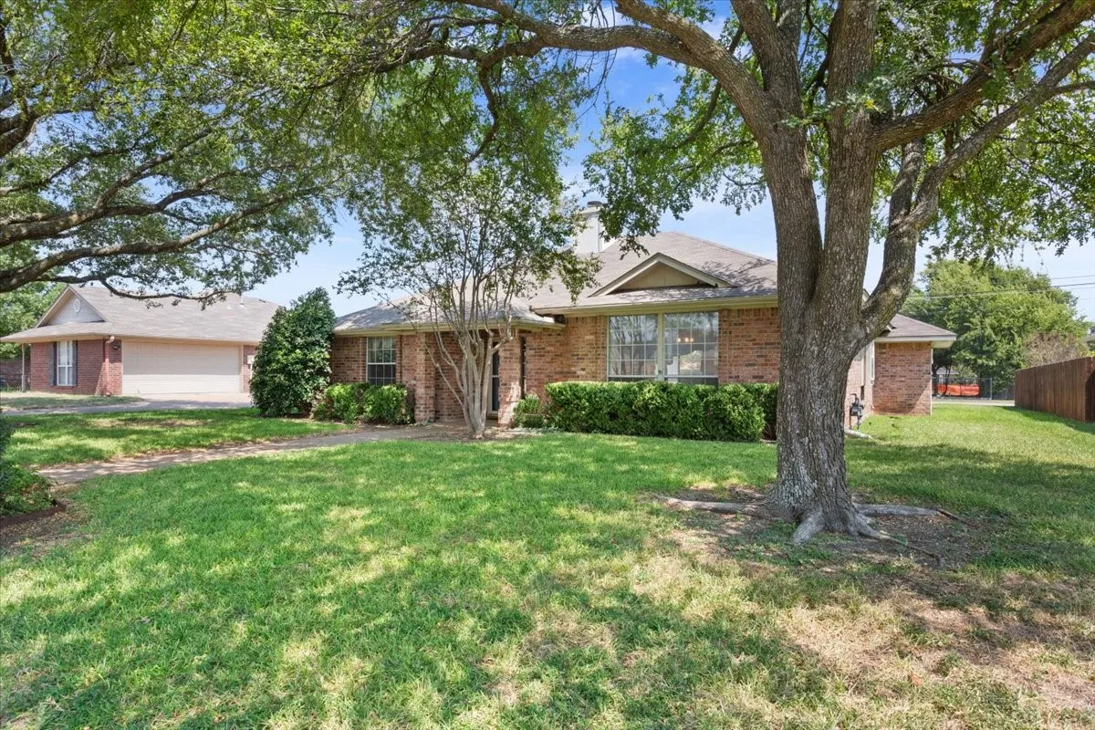Single story home featuring brick siding, a front lawn, and a garage