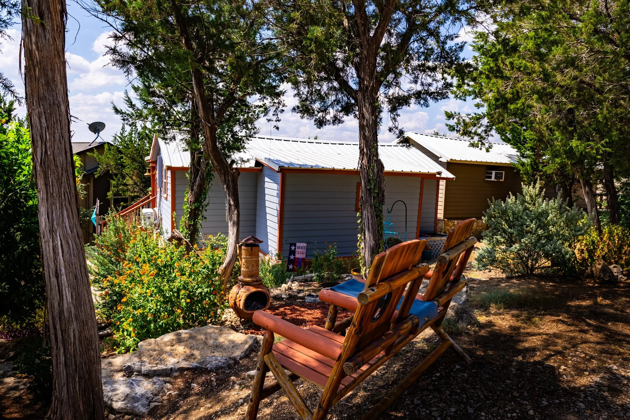 A wider view of the garden seating area with views of neighboring cabins.