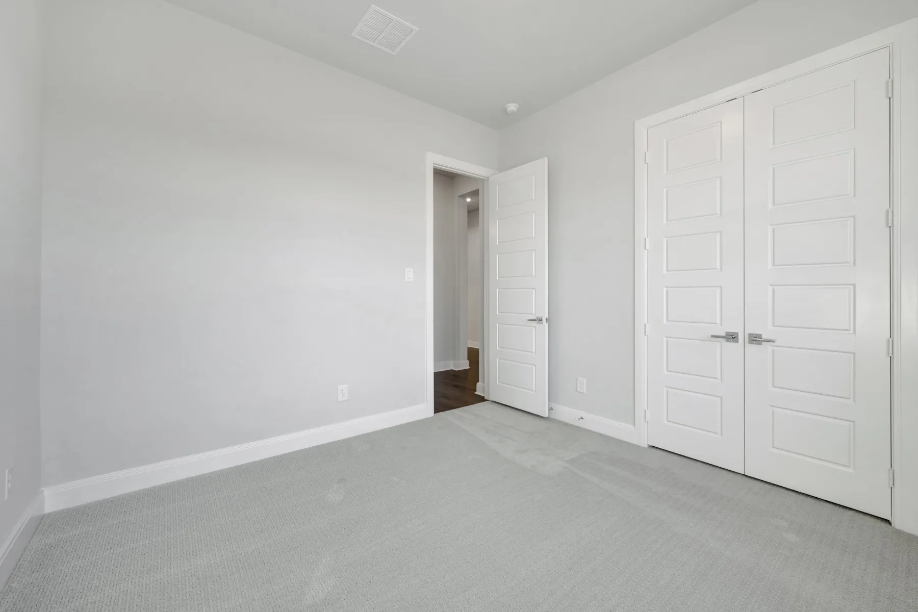 Unfurnished bedroom featuring light carpet and a closet