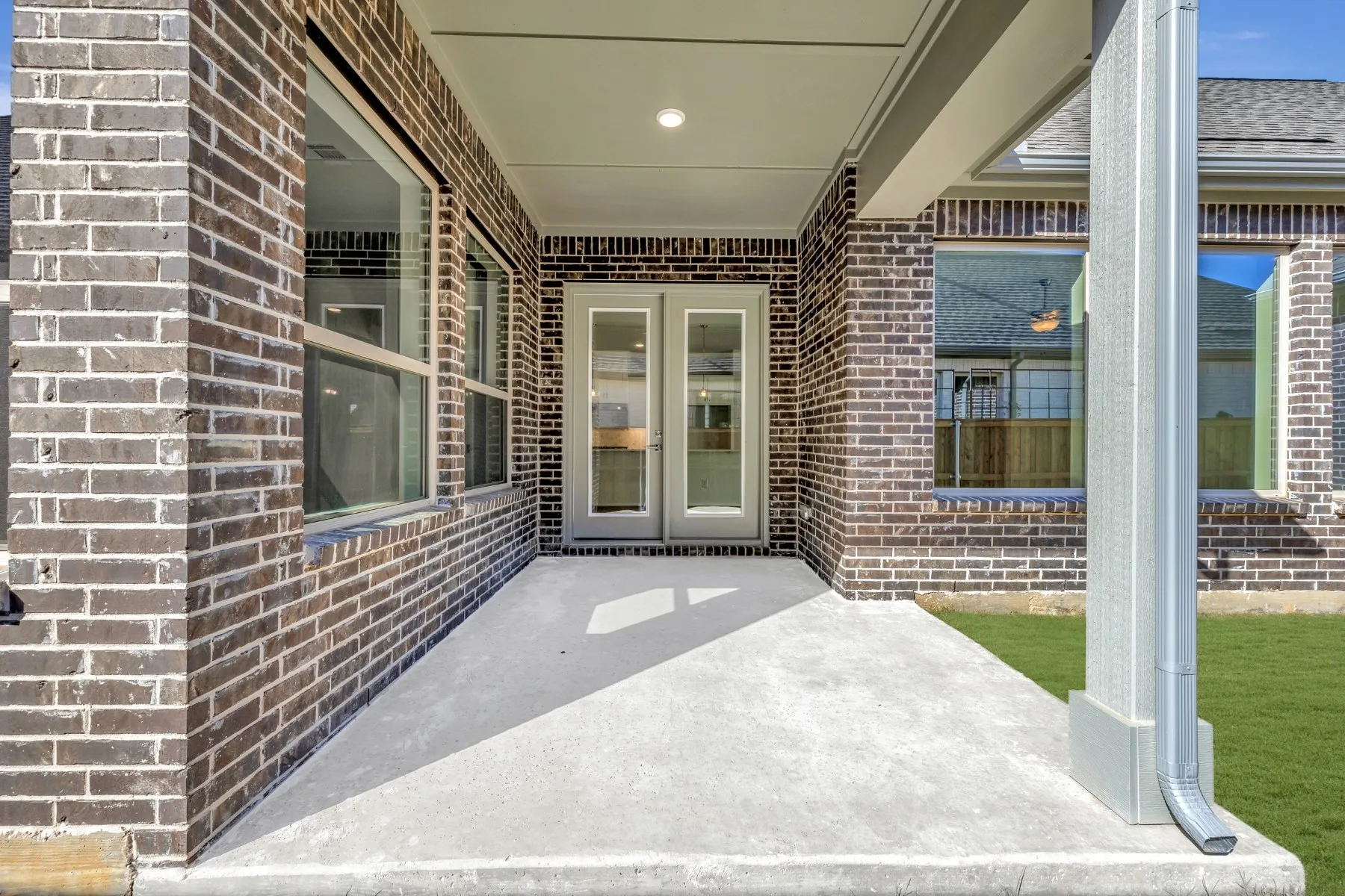 Property entrance with brick siding and a patio area