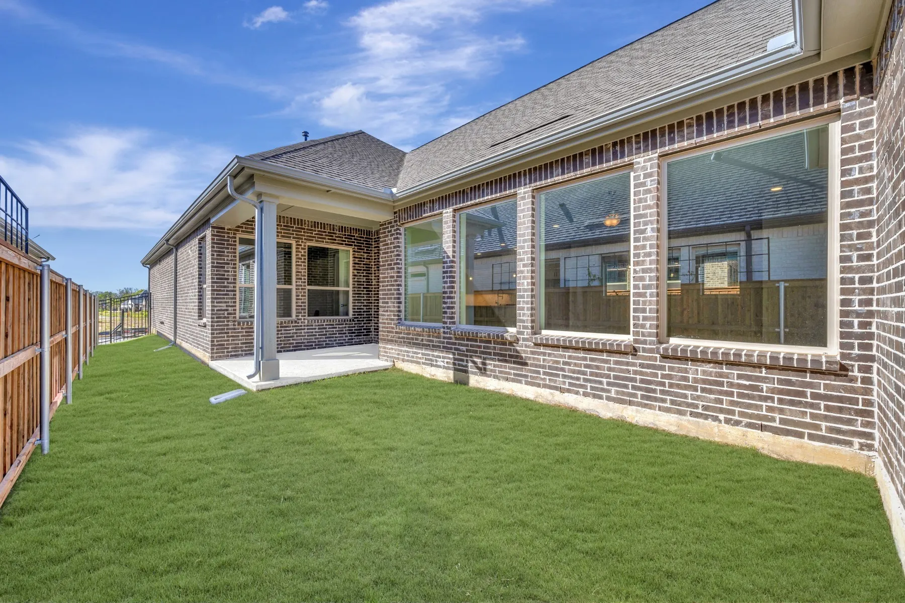 Rear view of property featuring a patio area, brick siding, and a shingled roof