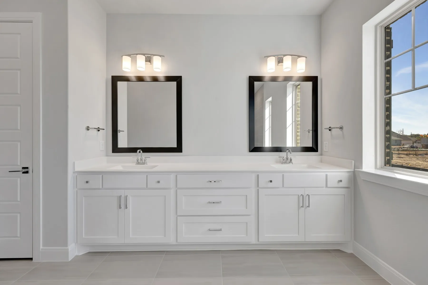 Full bath featuring double vanity and light tile patterned floors