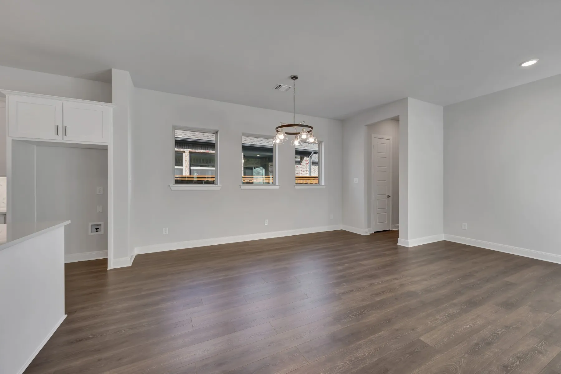 Unfurnished dining area featuring dark wood-style flooring and a chandelier