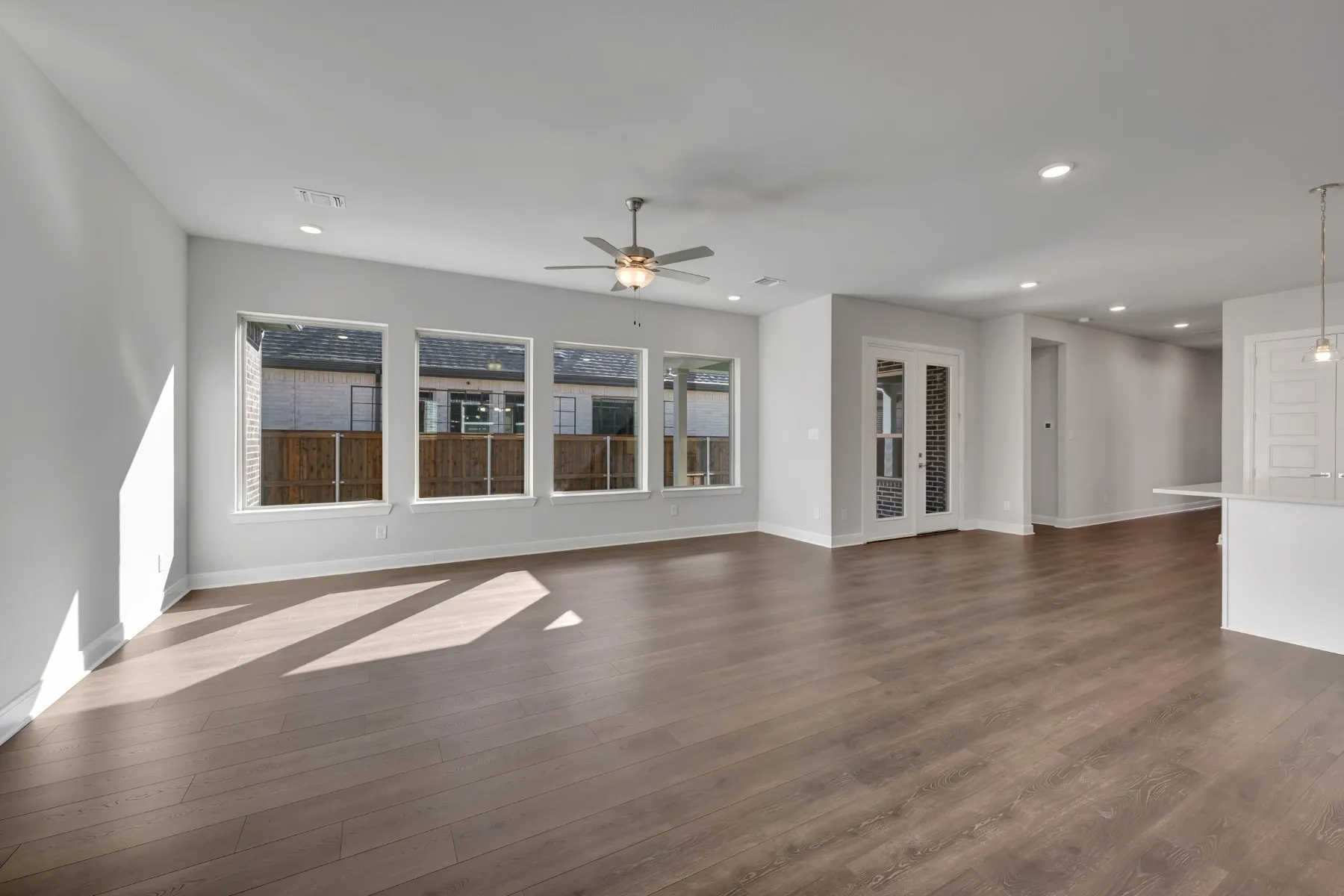 Unfurnished living room featuring a ceiling fan, dark wood-style flooring, and recessed lighting