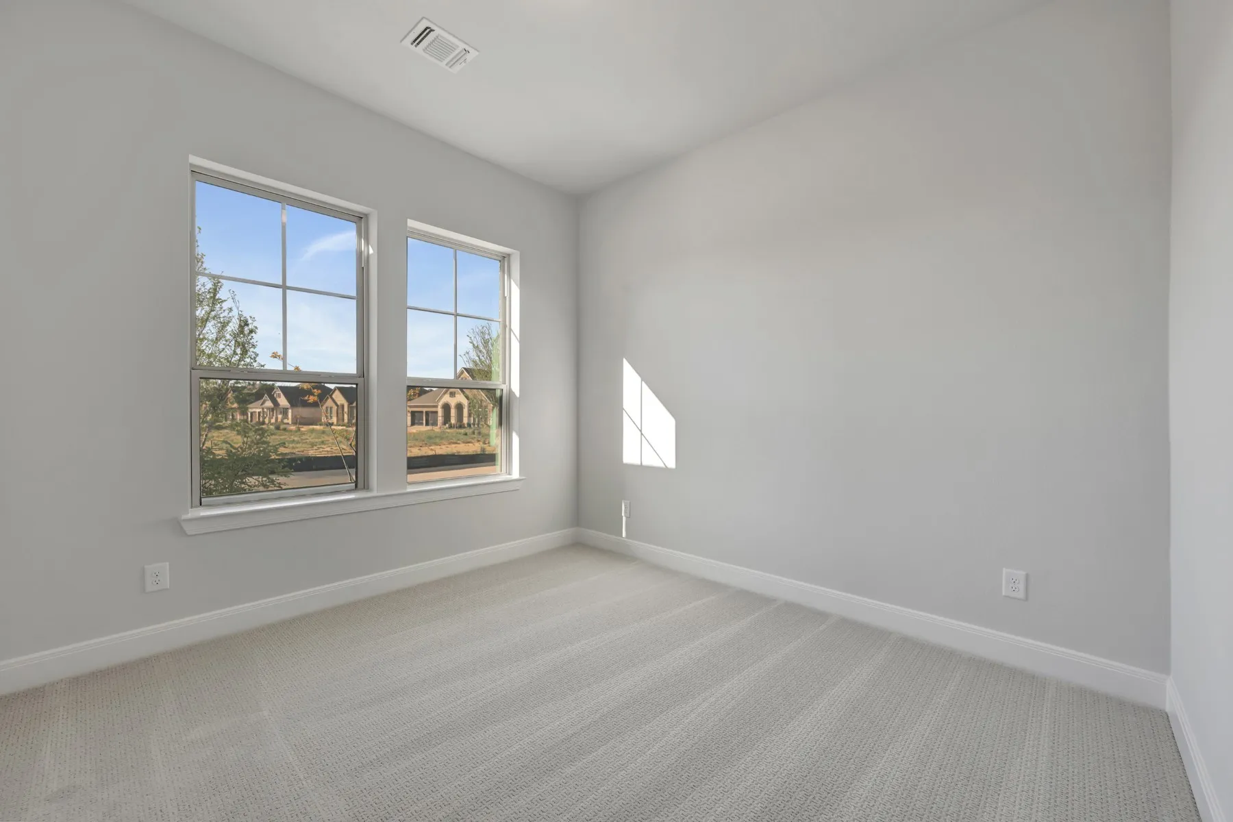 Empty room with light carpet and baseboards