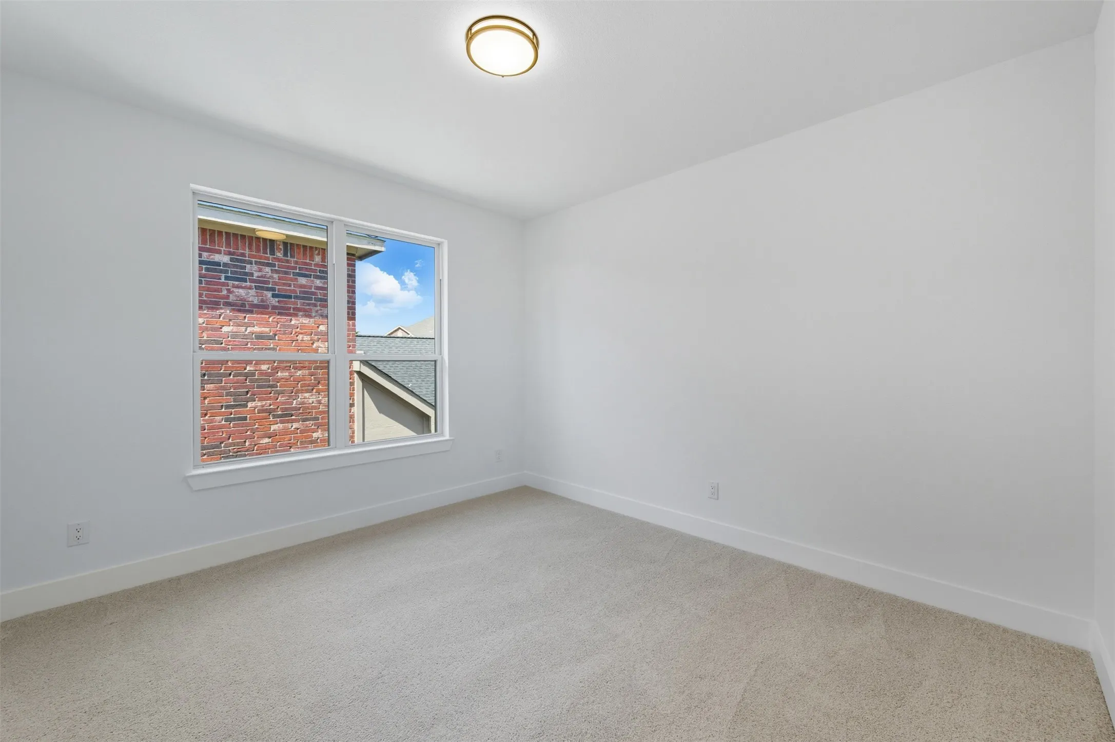 Spare room with light colored carpet and baseboards