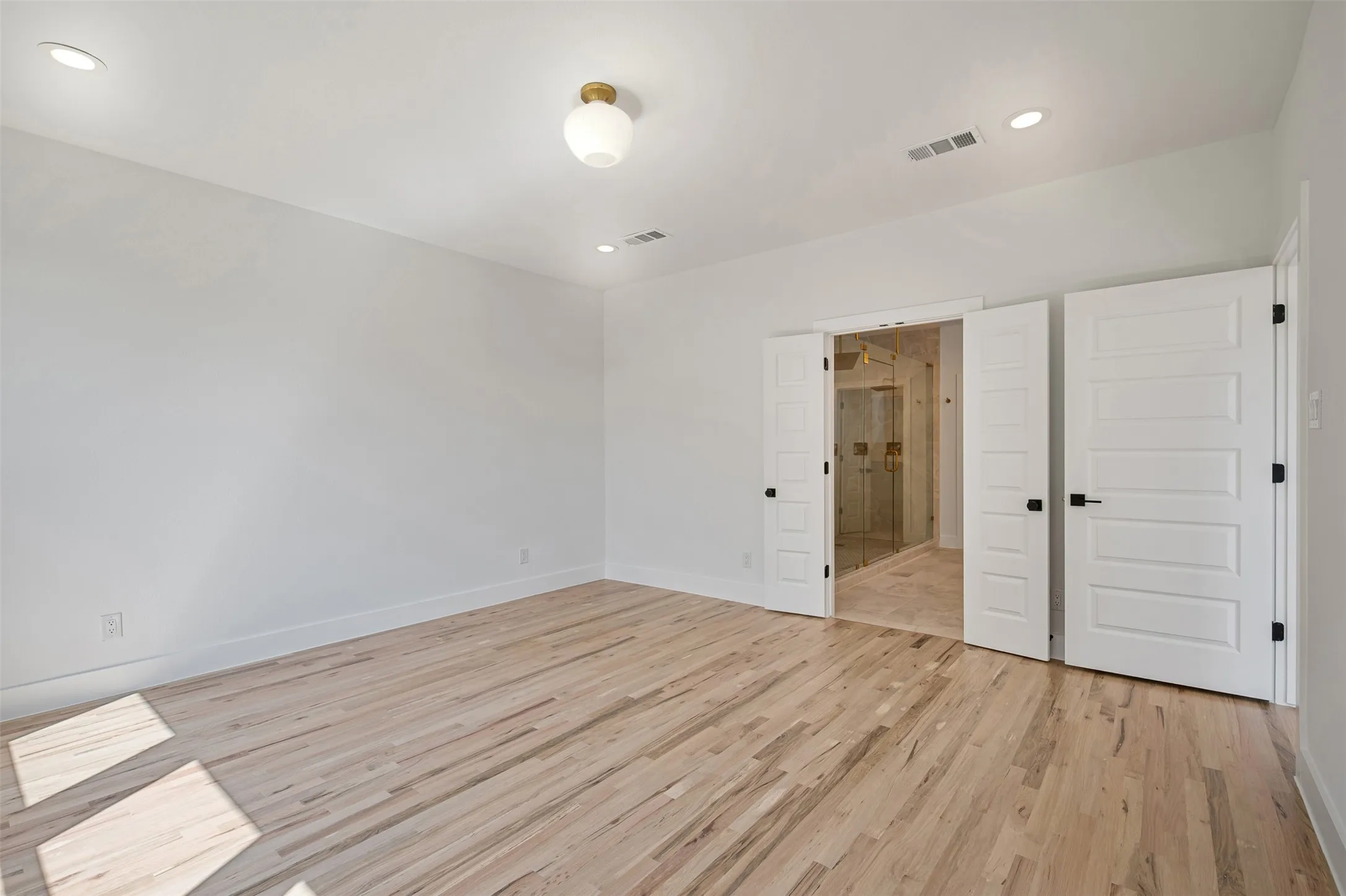 Unfurnished bedroom featuring light wood finished floors, recessed lighting, and ensuite bath
