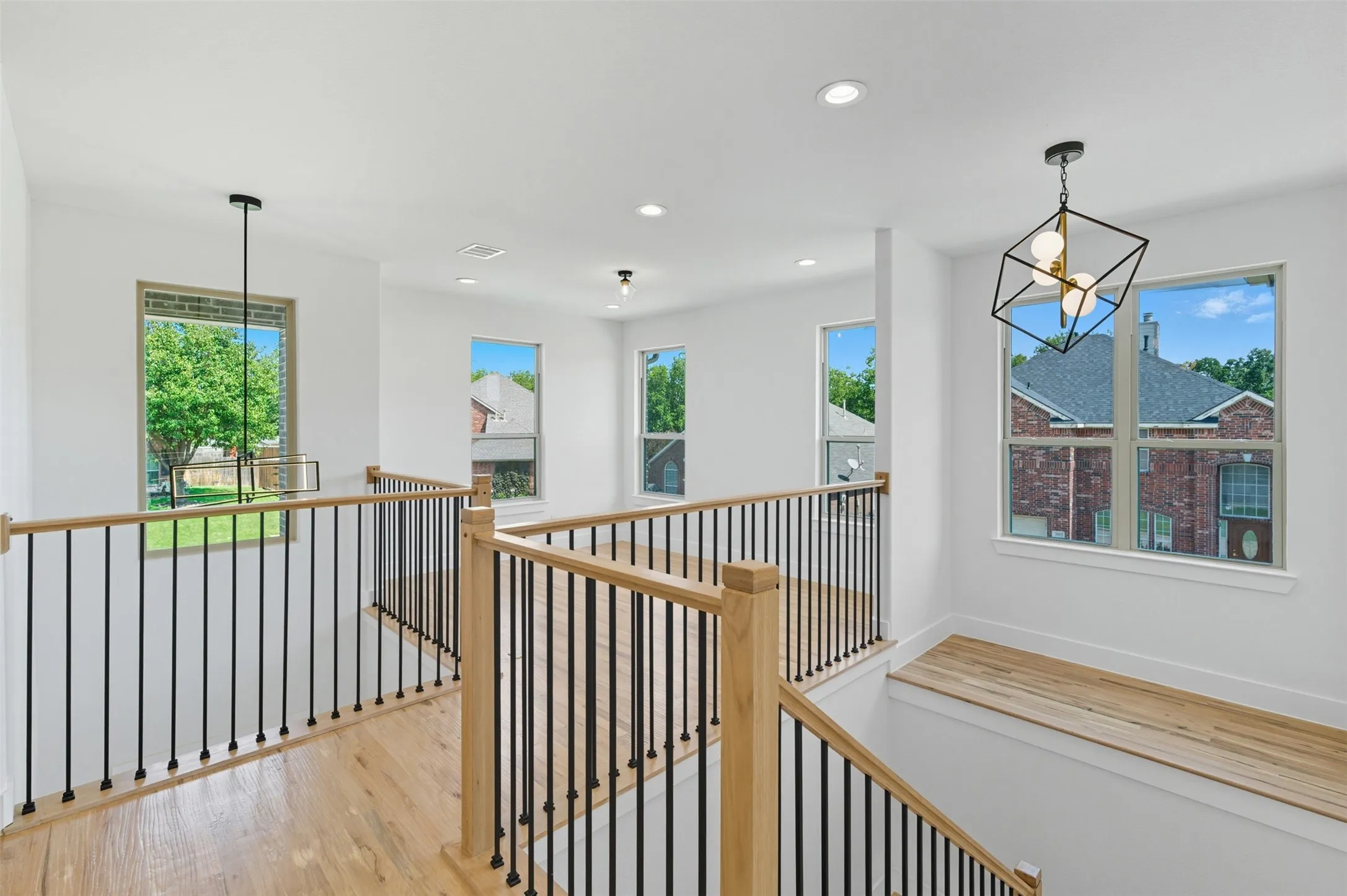 Corridor with a chandelier, light wood-style floors, recessed lighting, and an upstairs landing