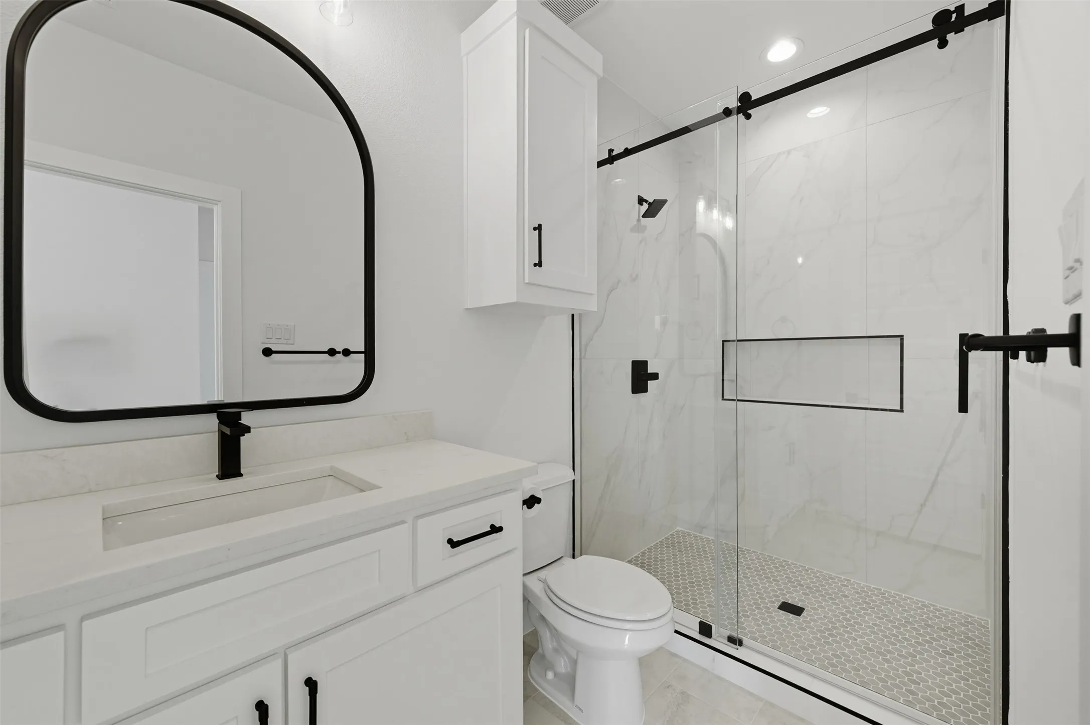 Full bath featuring a marble finish shower, vanity, recessed lighting, and light tile patterned flooring