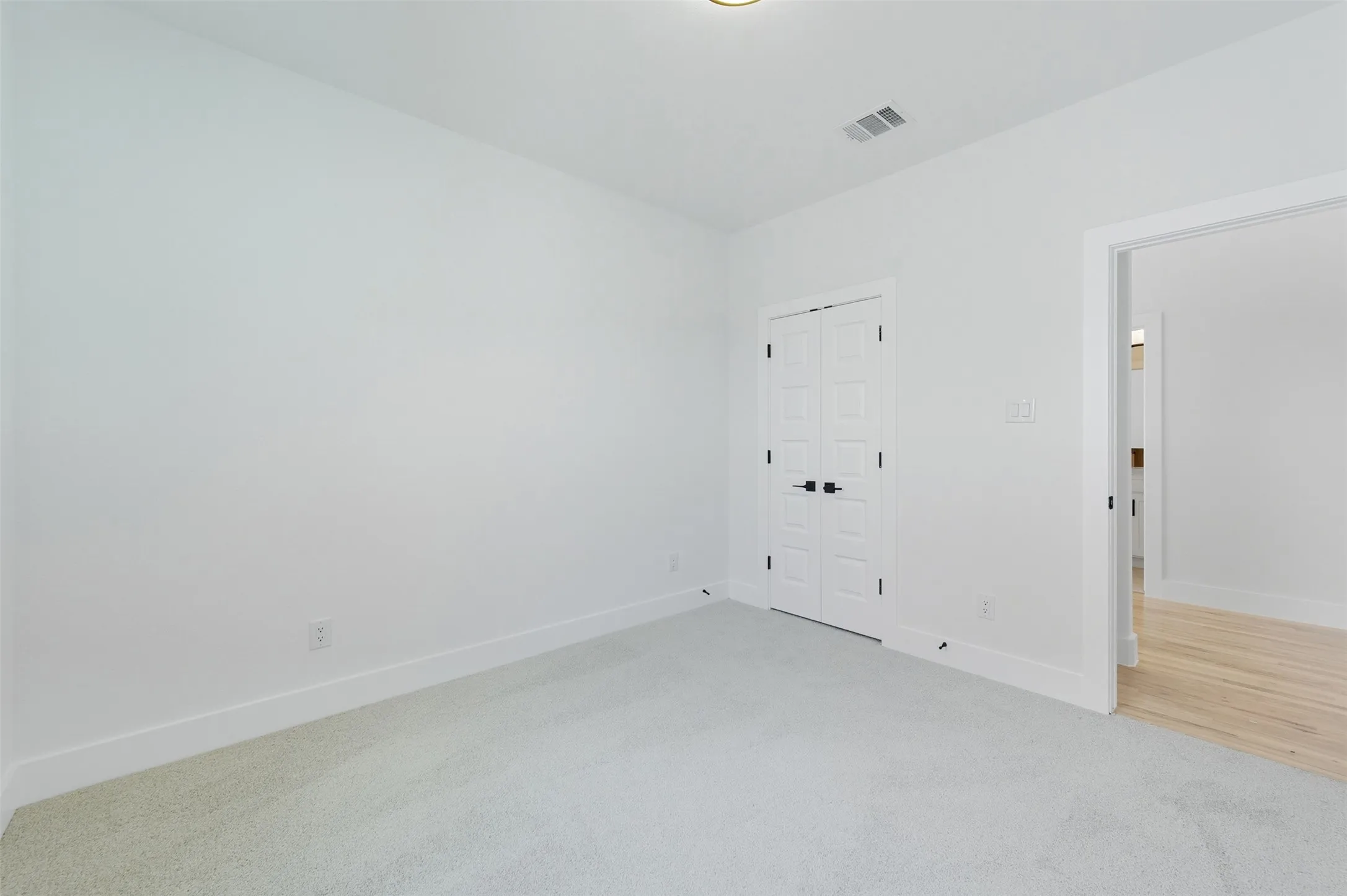 Unfurnished bedroom featuring light carpet and a closet