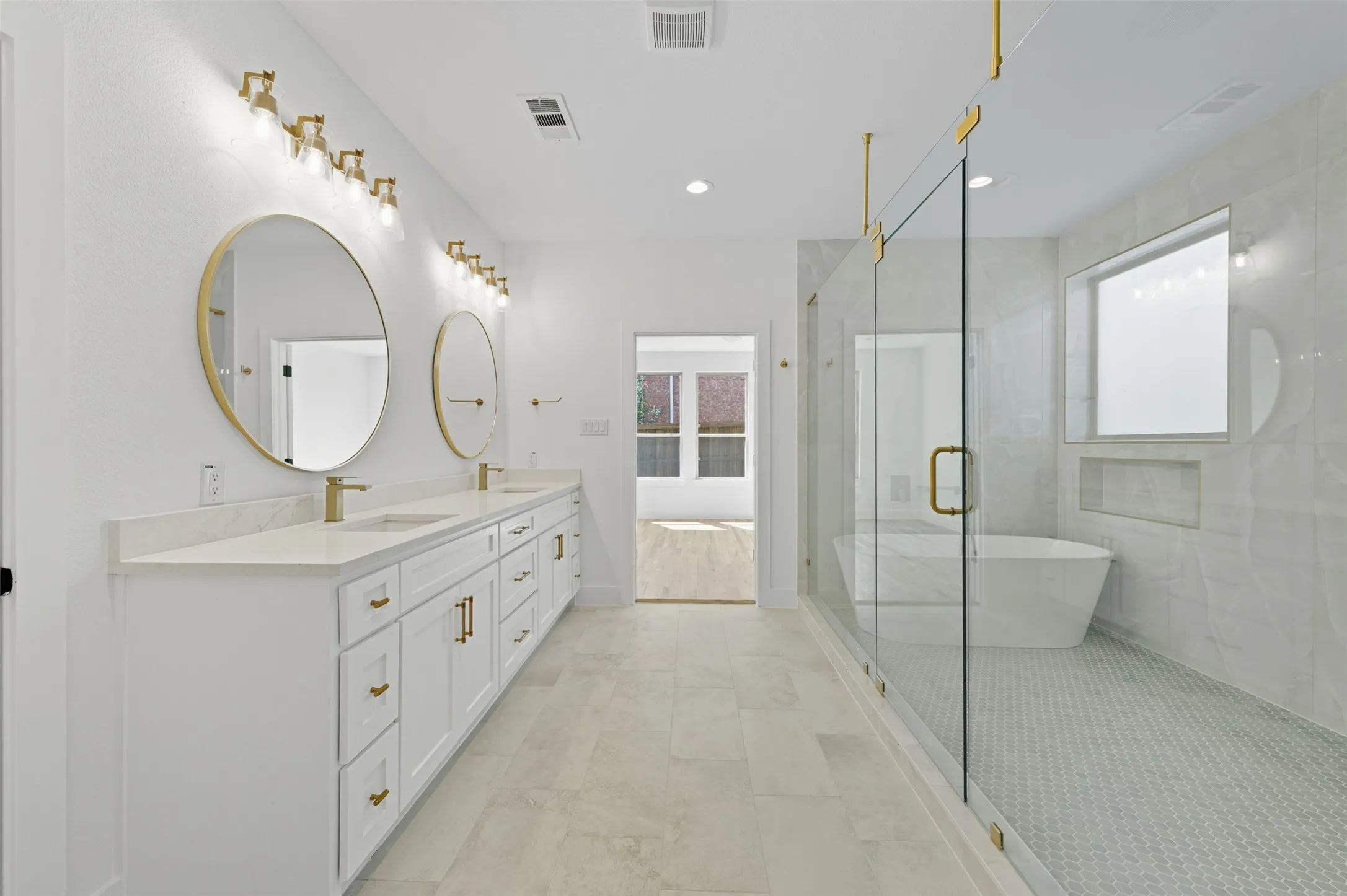 Full bath with a freestanding tub, a stall shower, double vanity, and recessed lighting