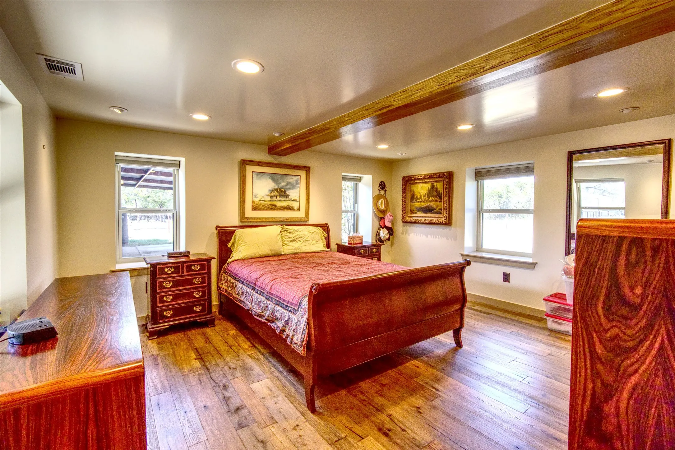 Bedroom featuring beamed ceiling, hardwood / wood-style floors, multiple windows, and recessed lighting