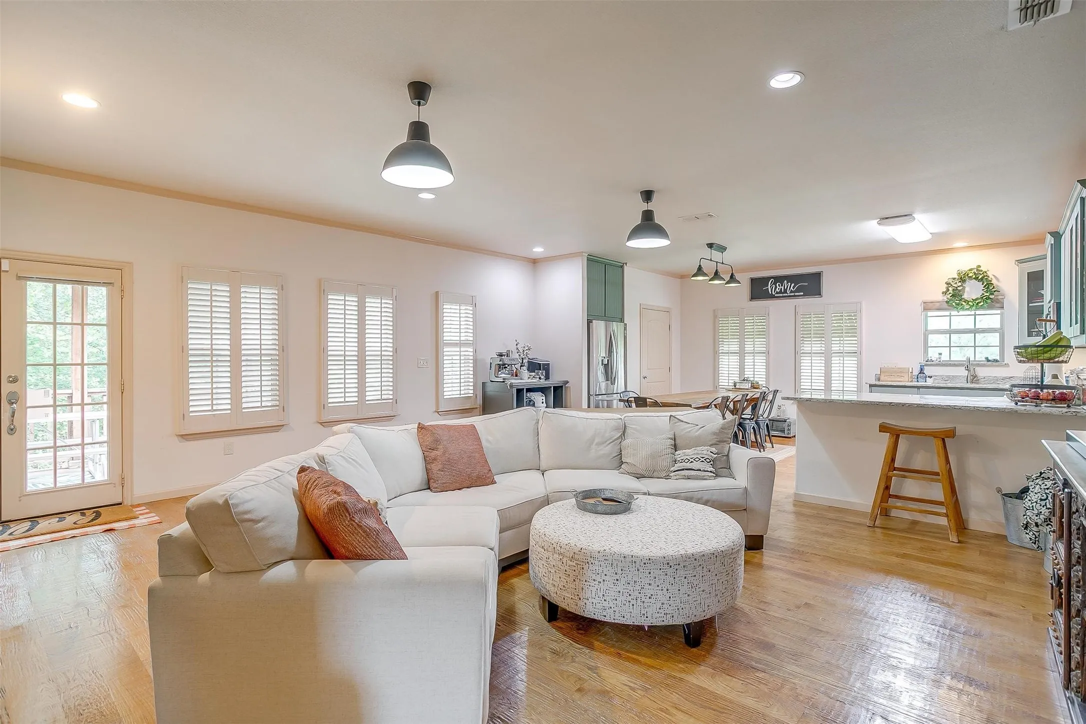 Living room featuring crown molding, light wood-style floors, and recessed lighting
