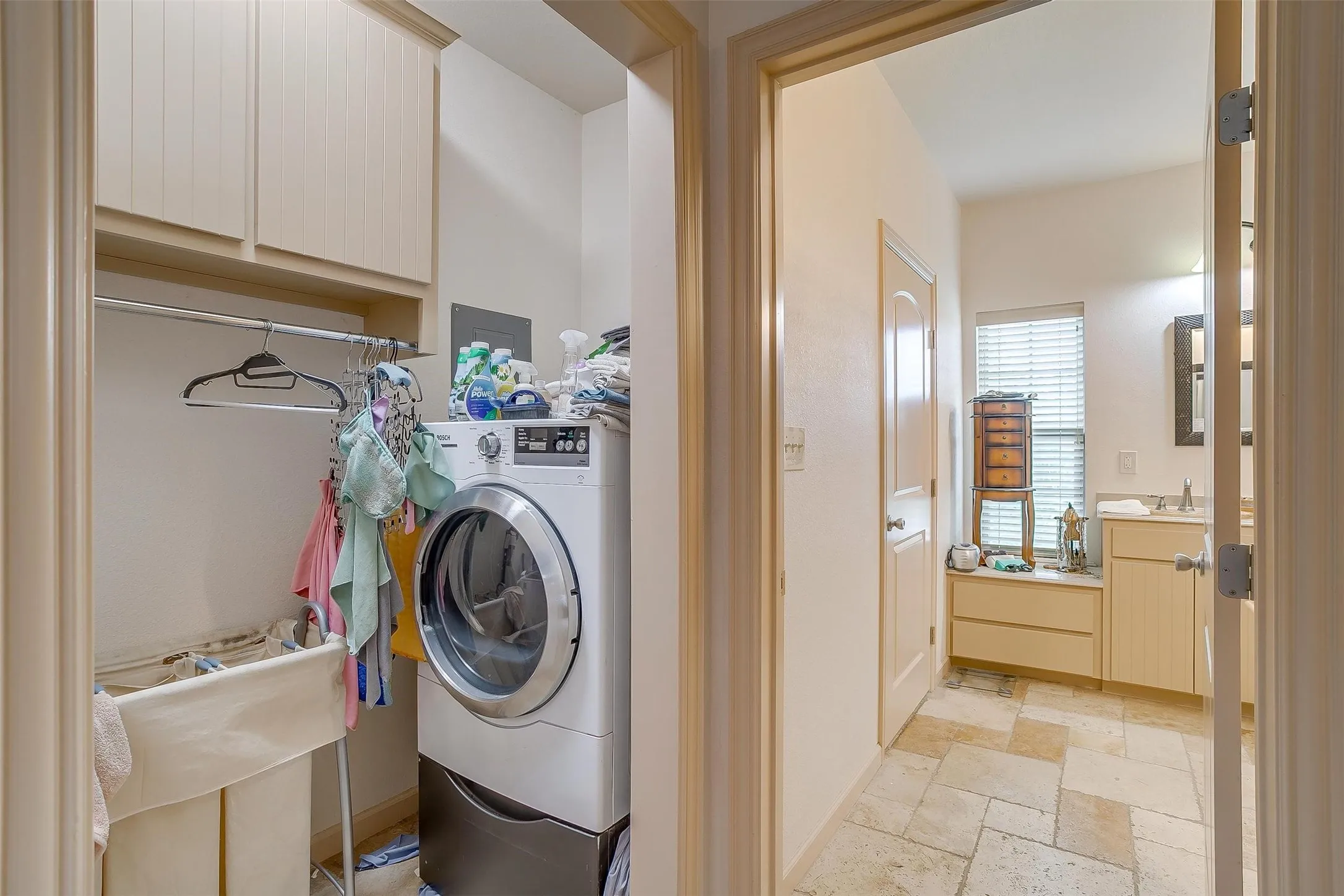 Laundry room featuring stone tile floors and washer / dryer